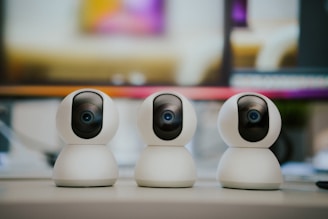 Three small white cameras sitting on top of a table - Surveillance Camera Installation - Metroplex S