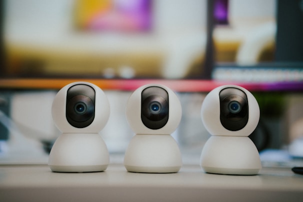 Three small white cameras sitting on top of a table