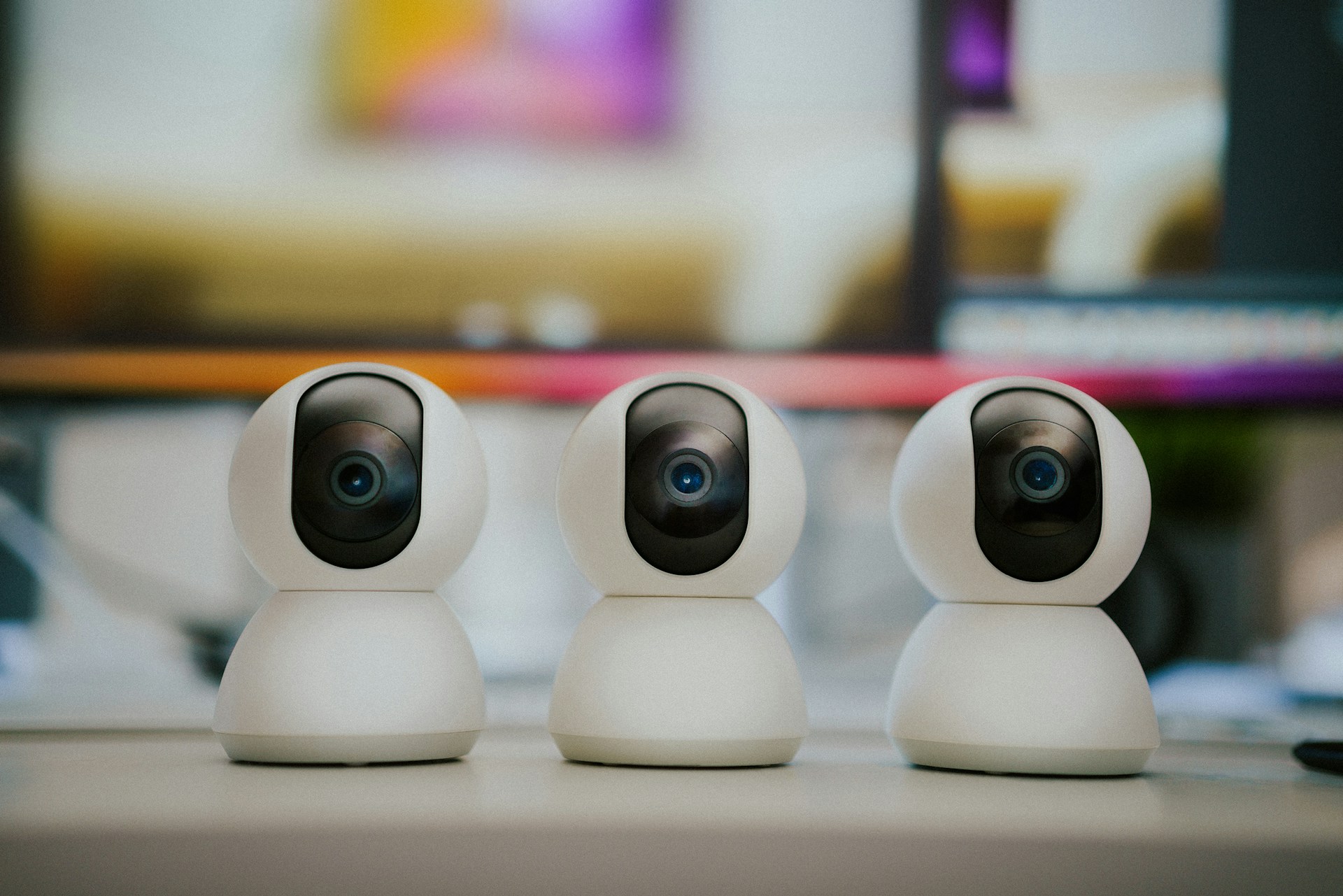 Three small white cameras sitting on top of a table