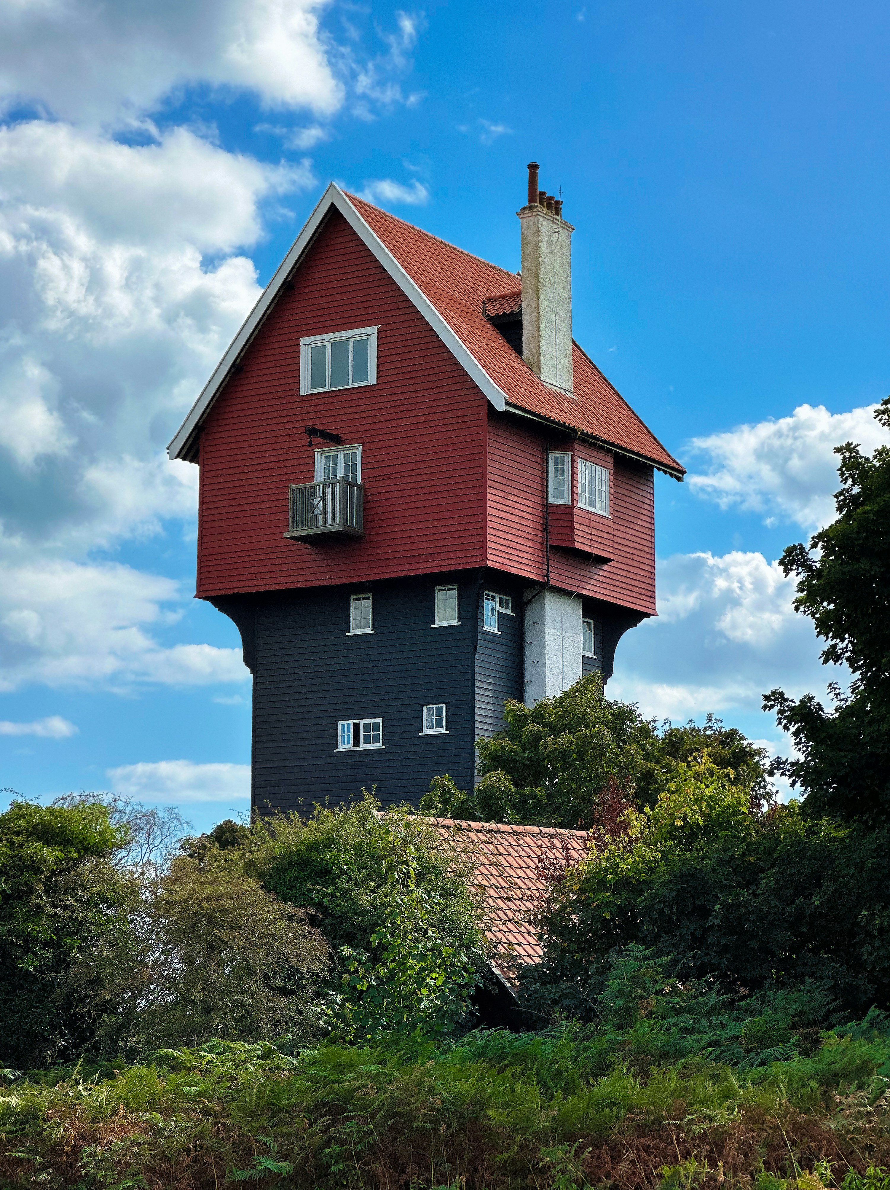 Une maison rouge et noire située au sommet d’une colline