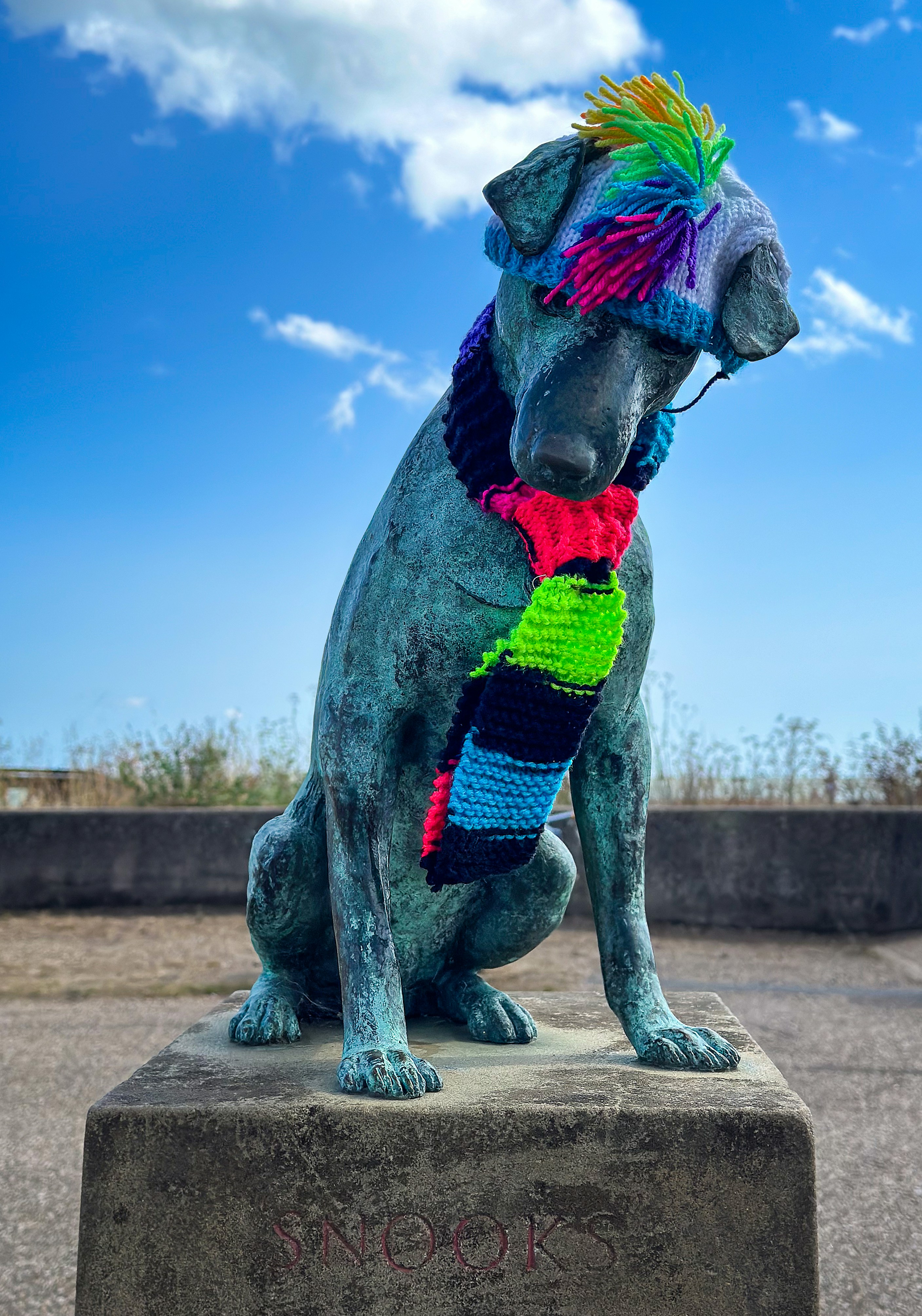 Une statue d’un chien portant un foulard