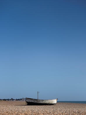 A boat sitting on top of a sandy beach