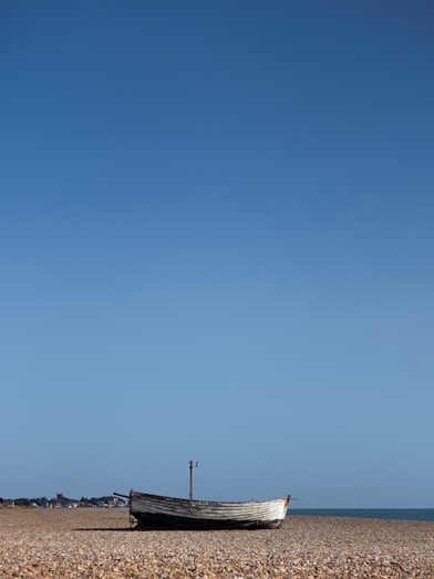 A boat sitting on top of a sandy beach