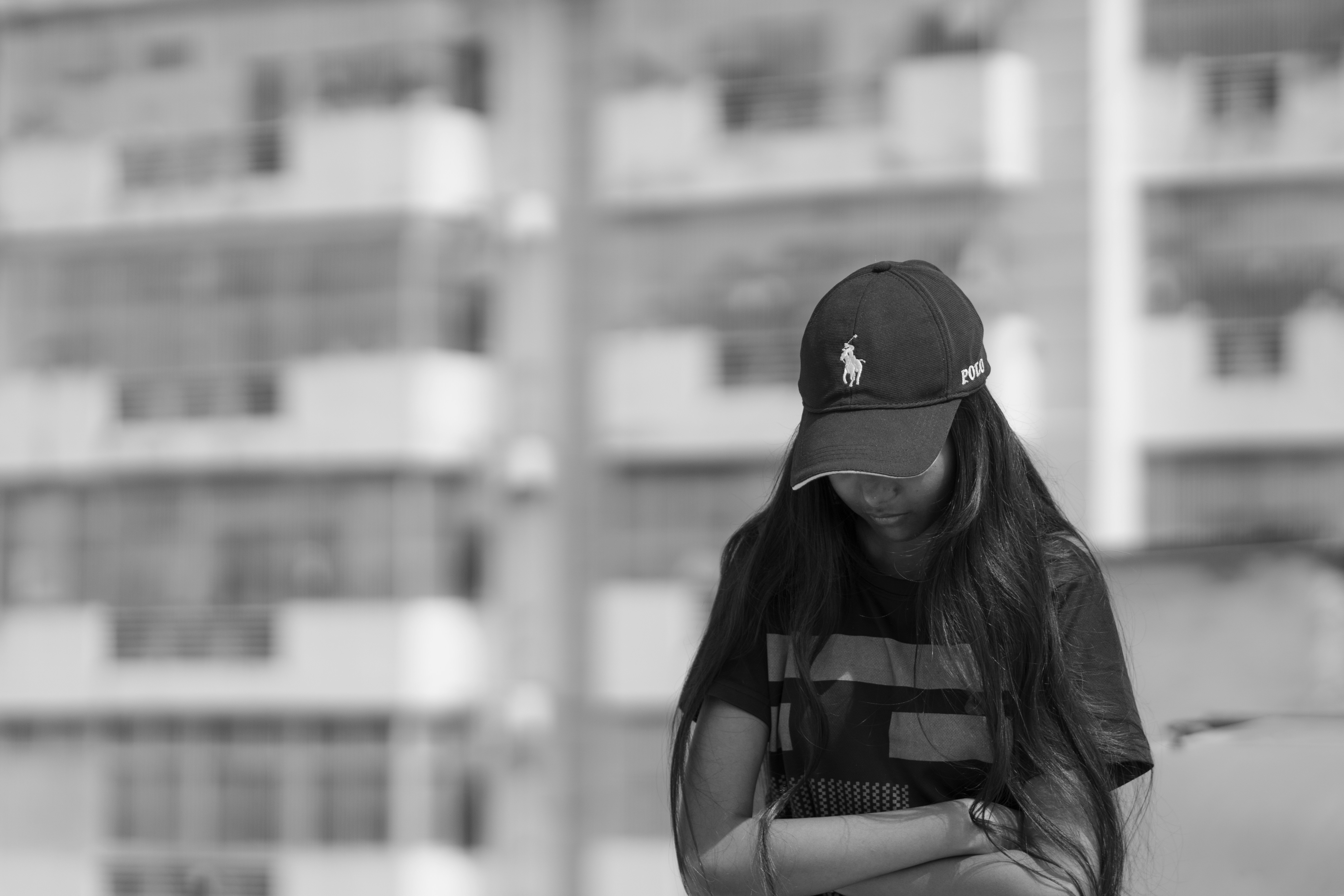 A woman in a baseball cap is standing on a skateboard