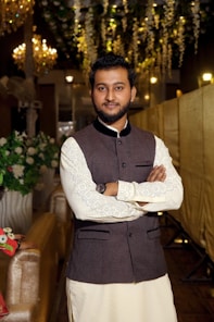 A man standing in a room with a chandelier hanging from the ceiling