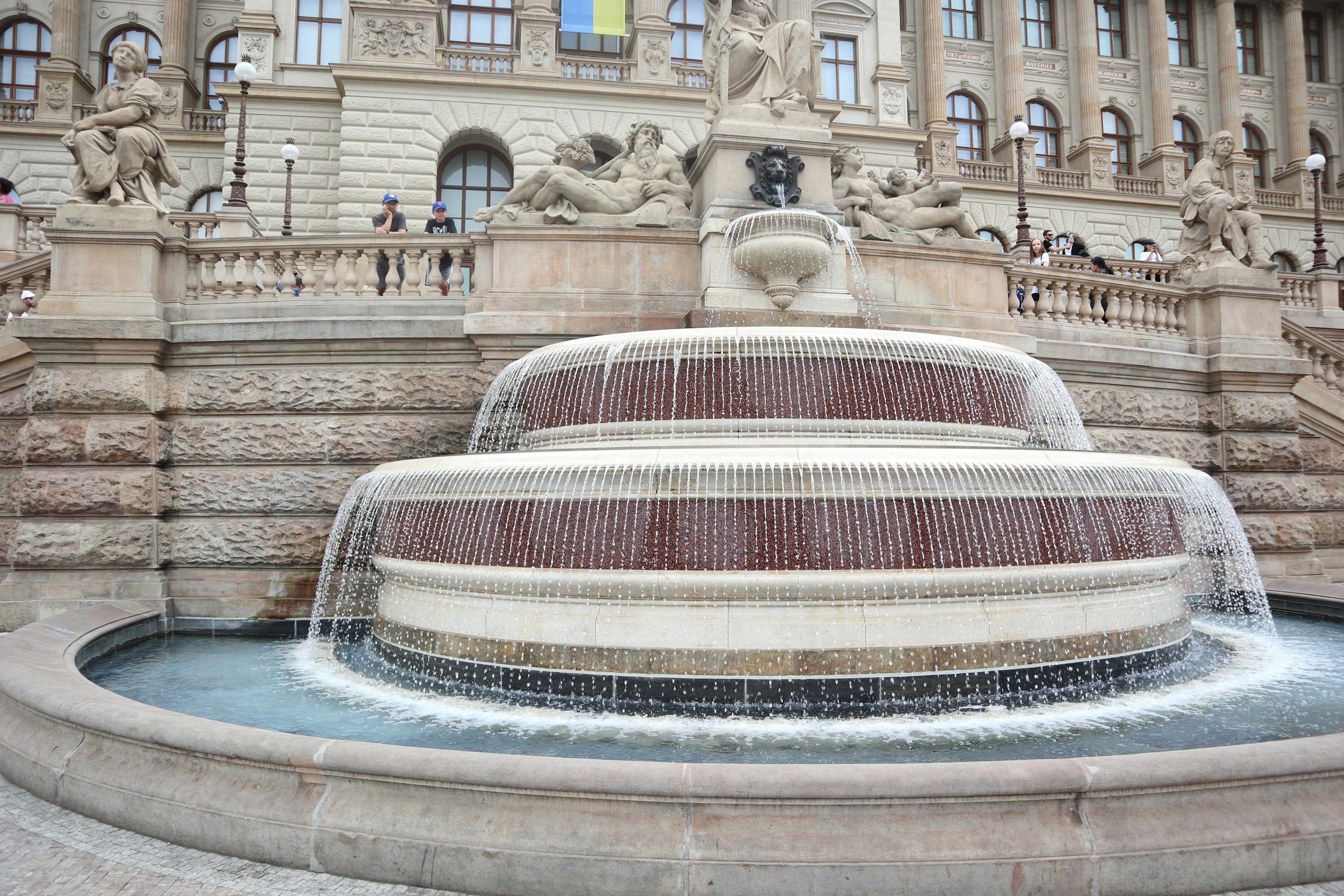 A large building with a fountain in front of it, 