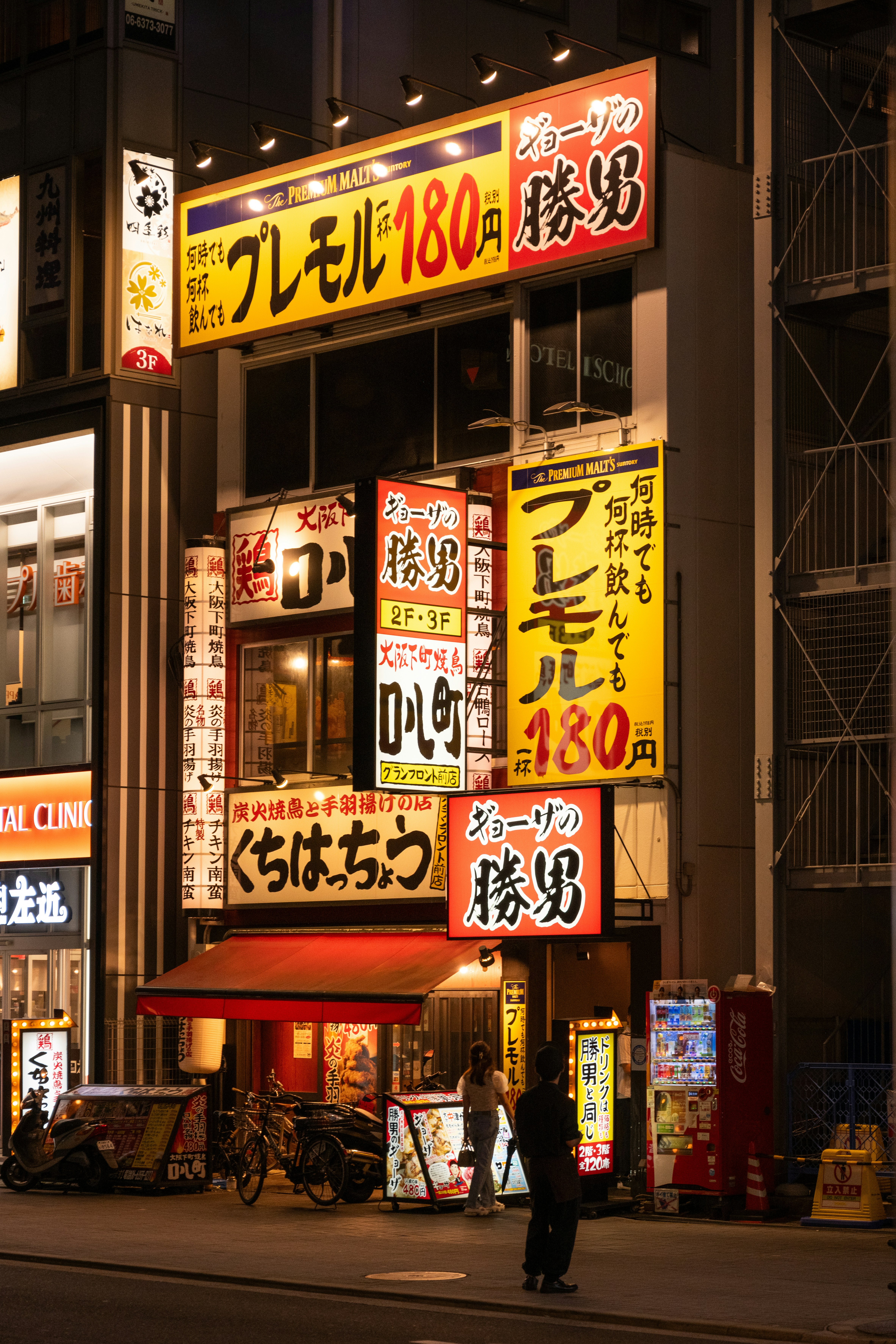 A city street at night filled with lots of signs