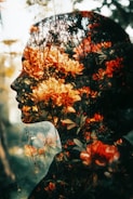 A double exposure of a woman's face with flowers in her hair