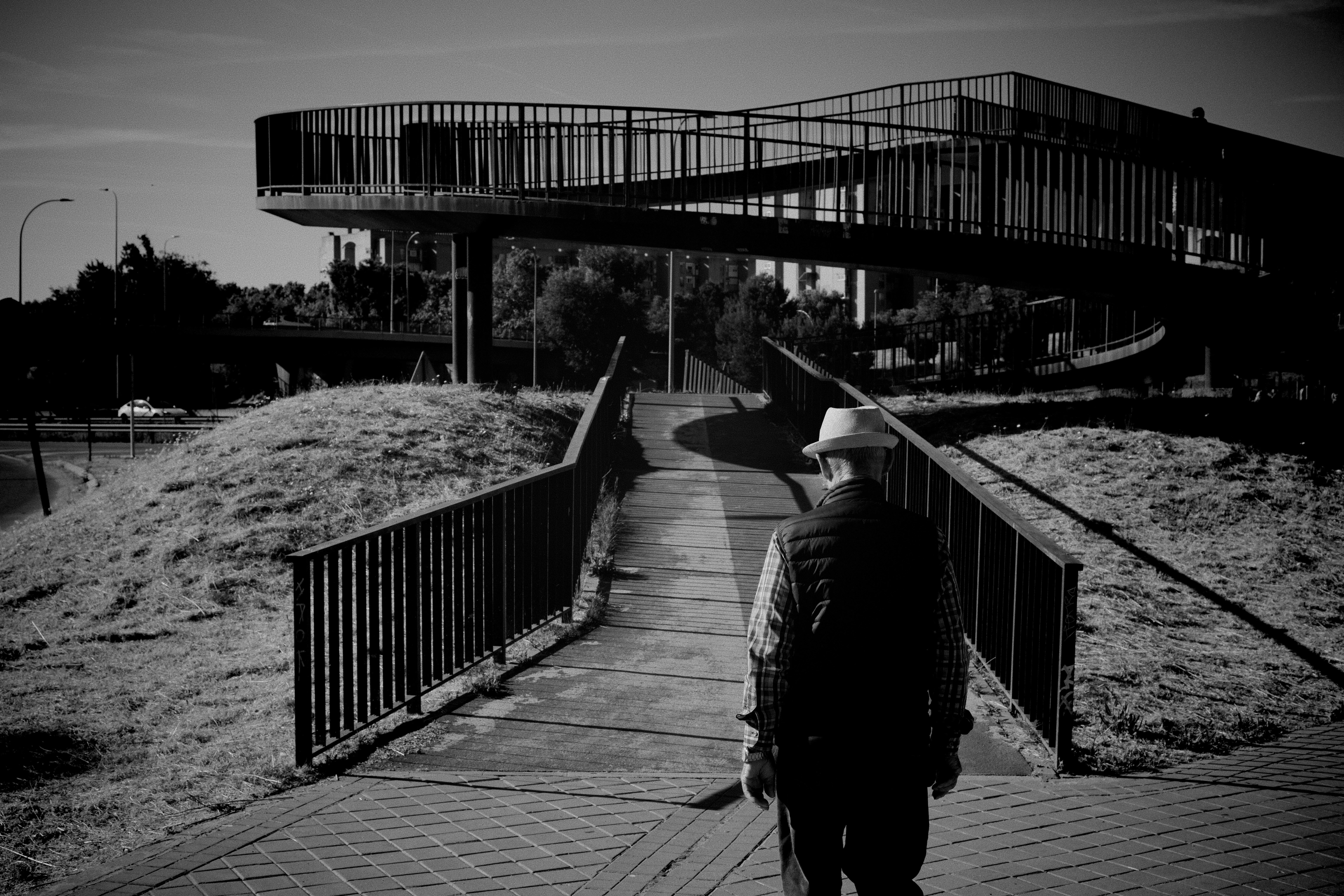 A man walking down a sidewalk next to a tall building