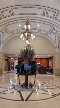 A lobby with a chandelier and a marble floor
