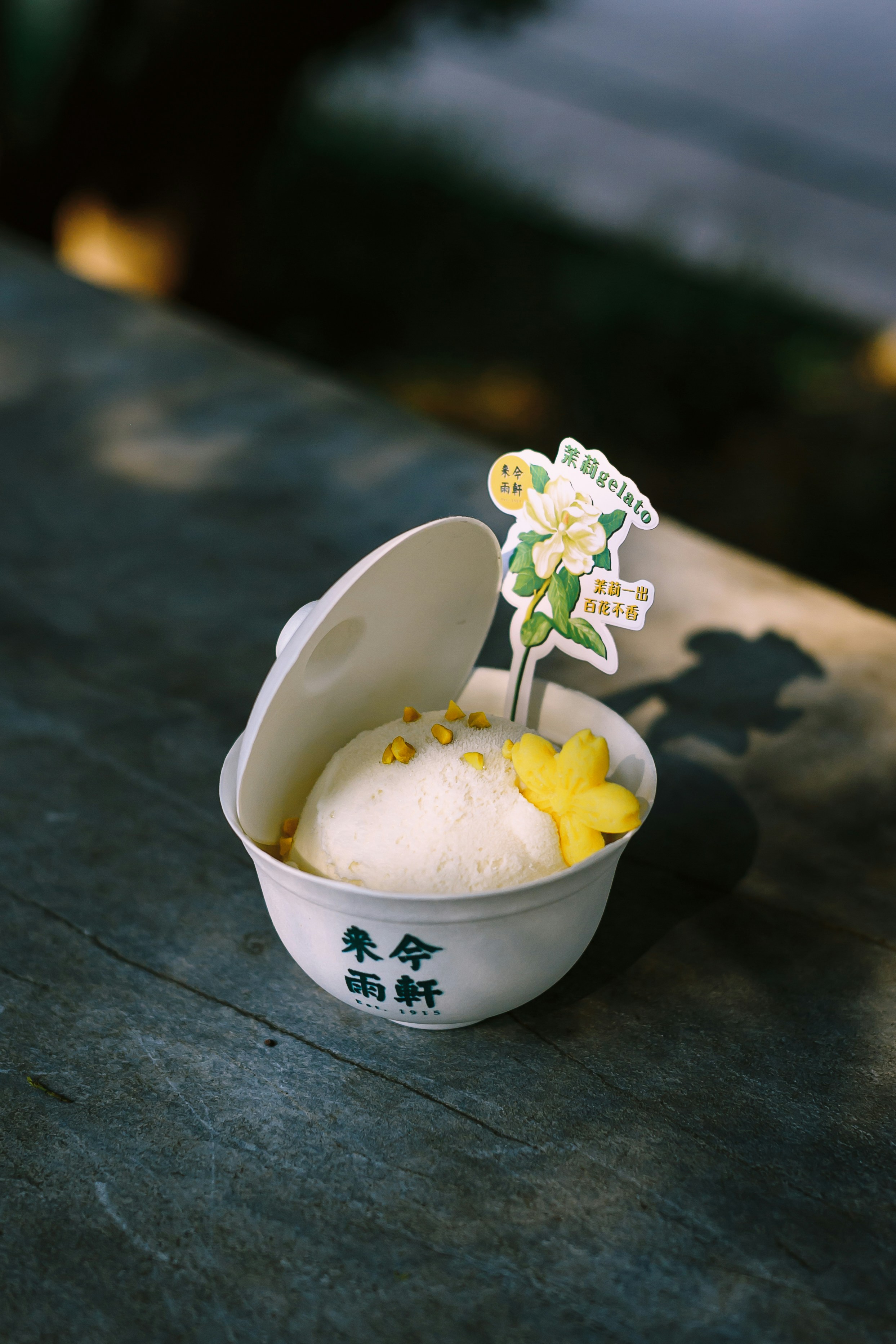 A bowl of ice cream with a flower sticking out of it