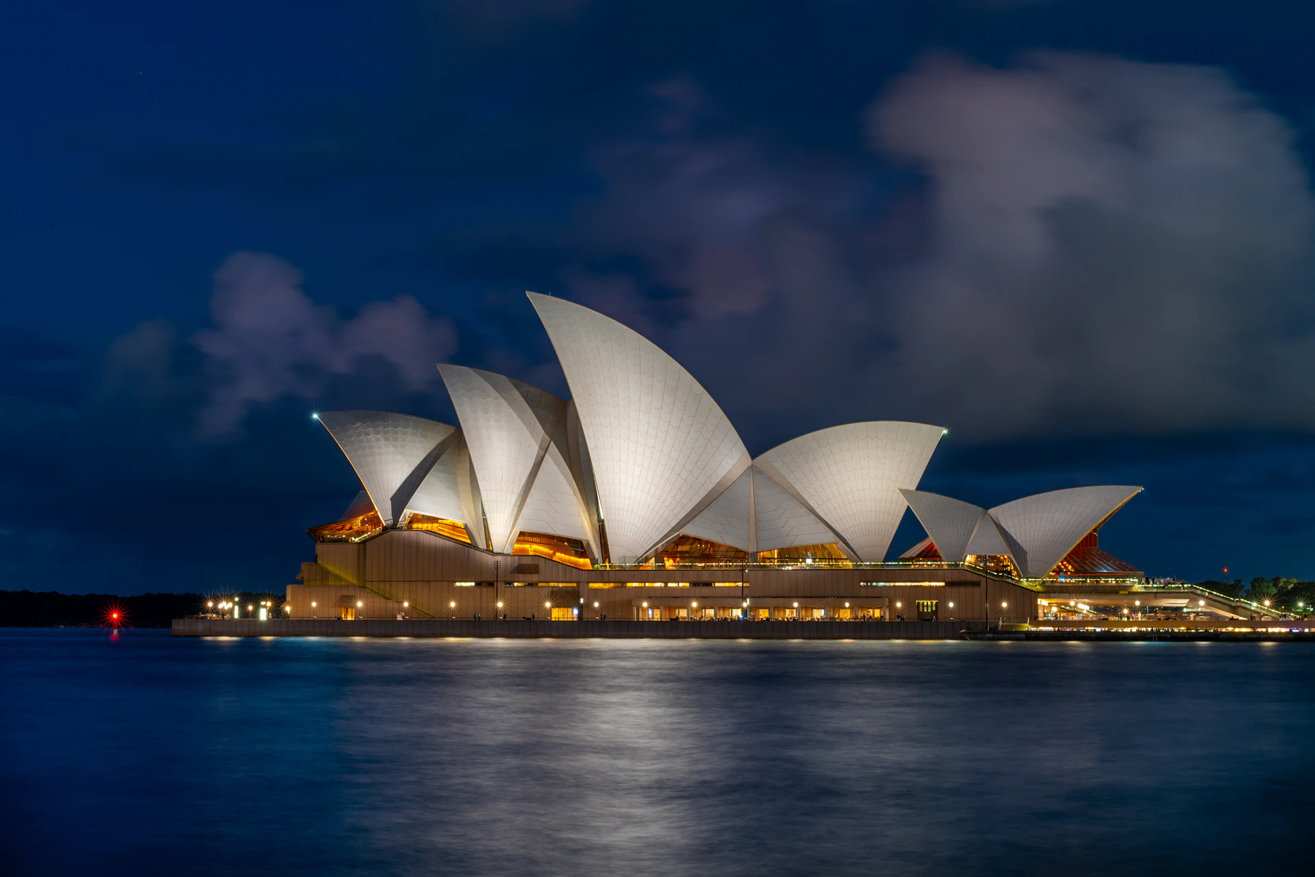 The sydney opera house lit up at night