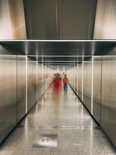 A group of people walking down a long hallway