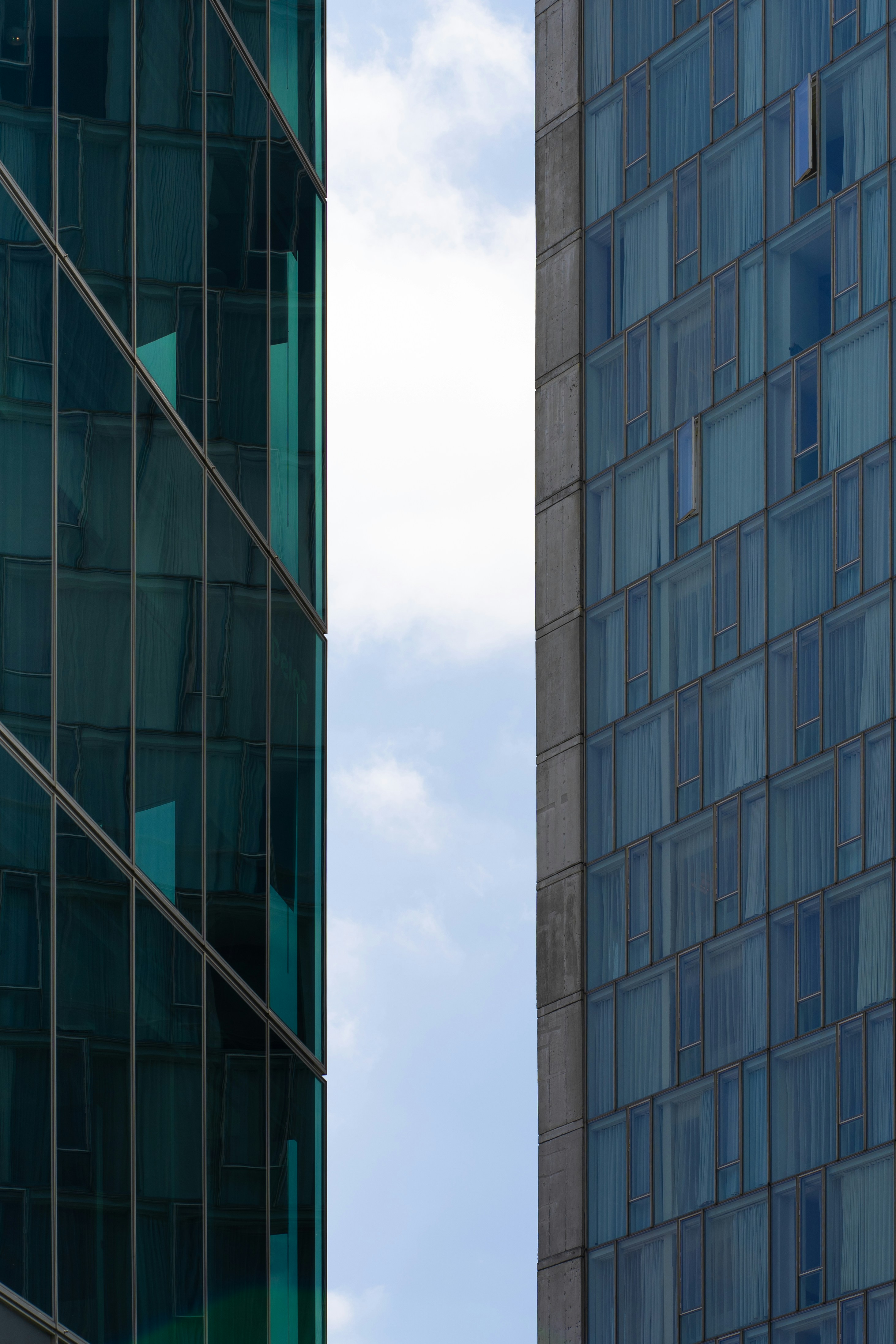 A tall building next to a very tall building