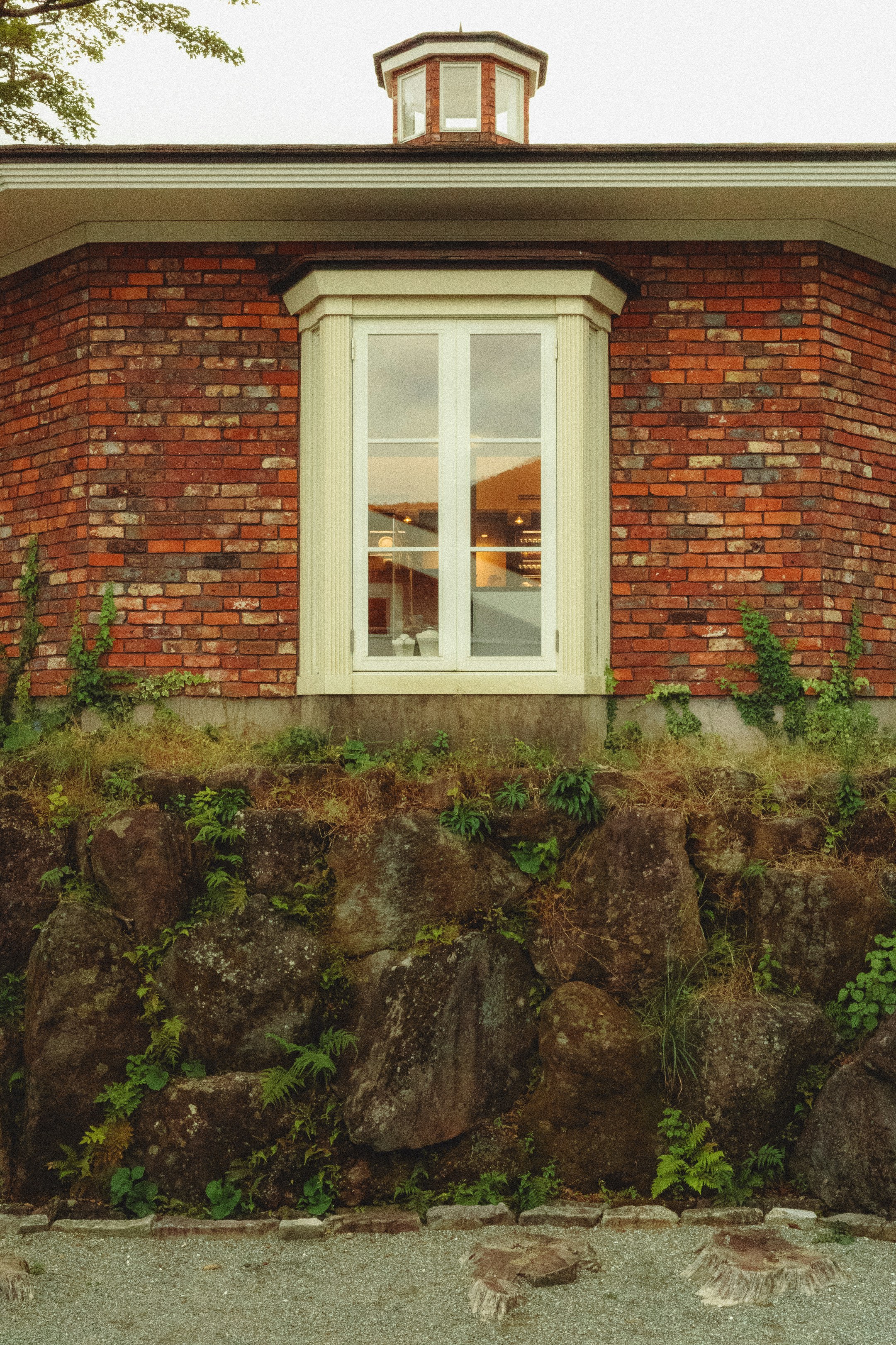 Un edificio in mattoni rossi con una finestra bianca