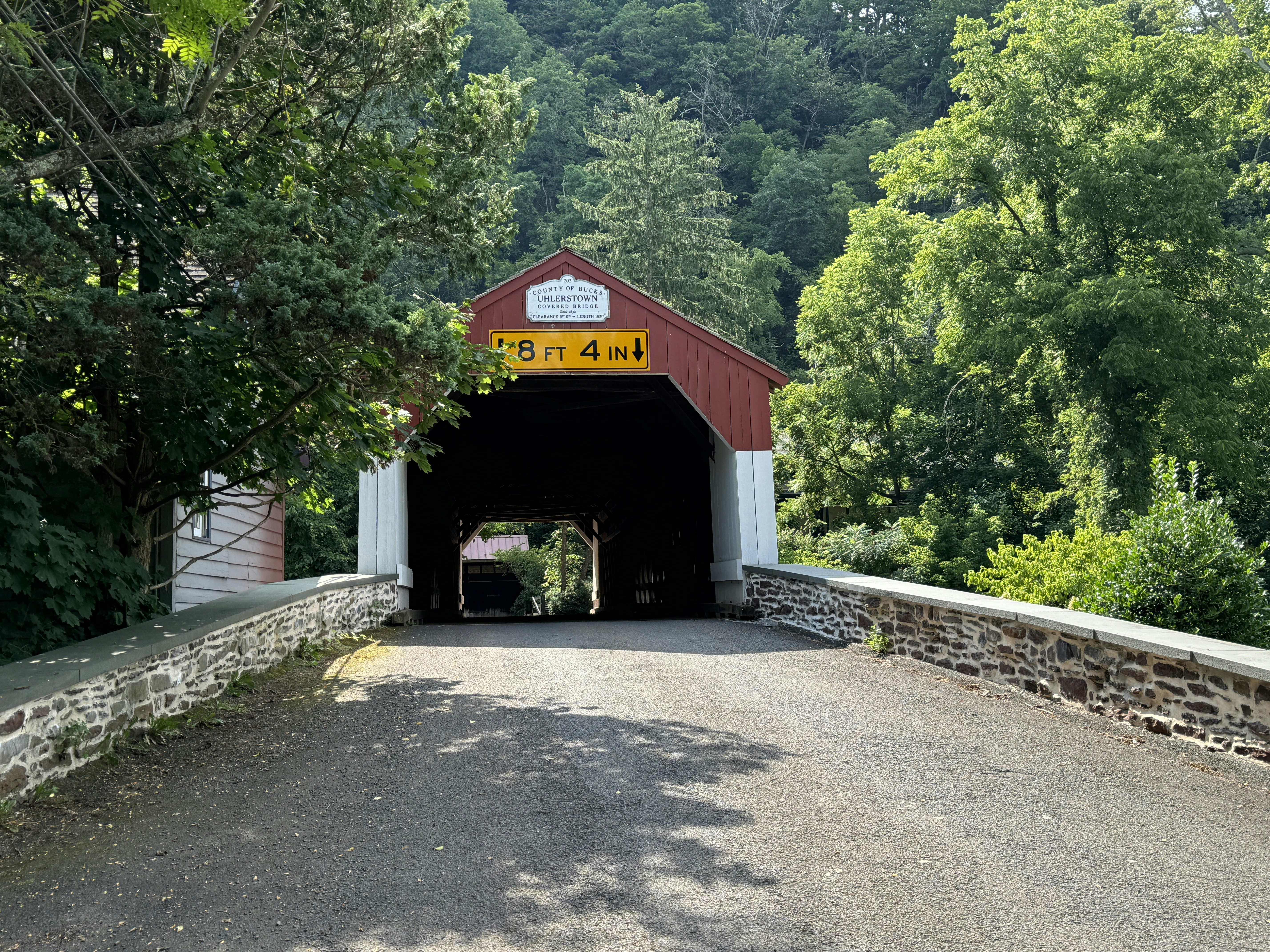 A red and white covered bridge with trees in the background