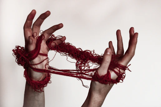 A person with their hands tied up to a string