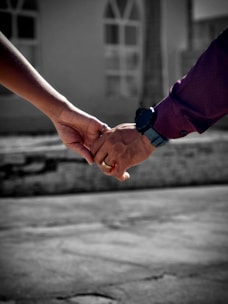 A couple holding hands while walking down a street