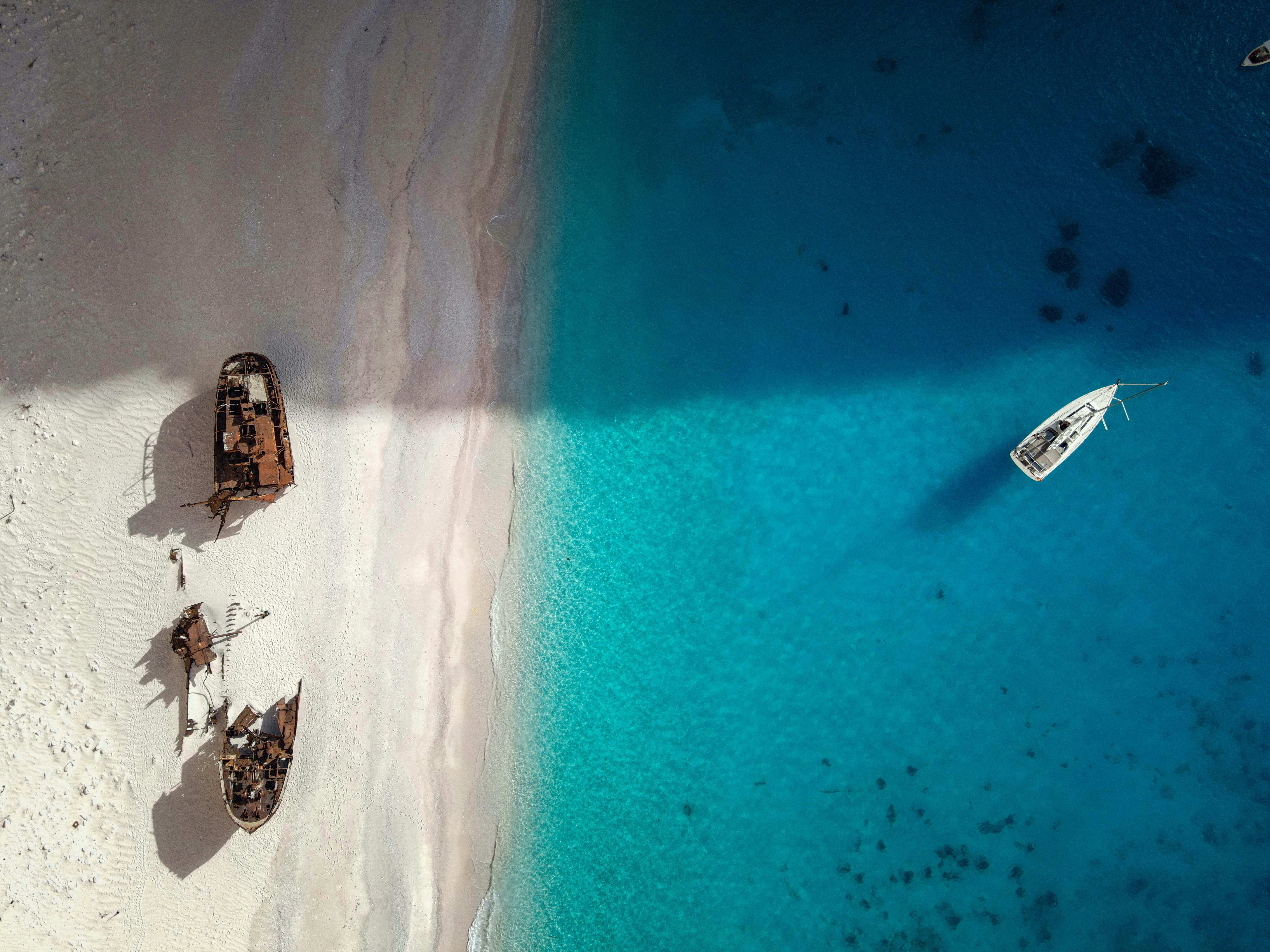 An aerial view of a beach with boats in the water