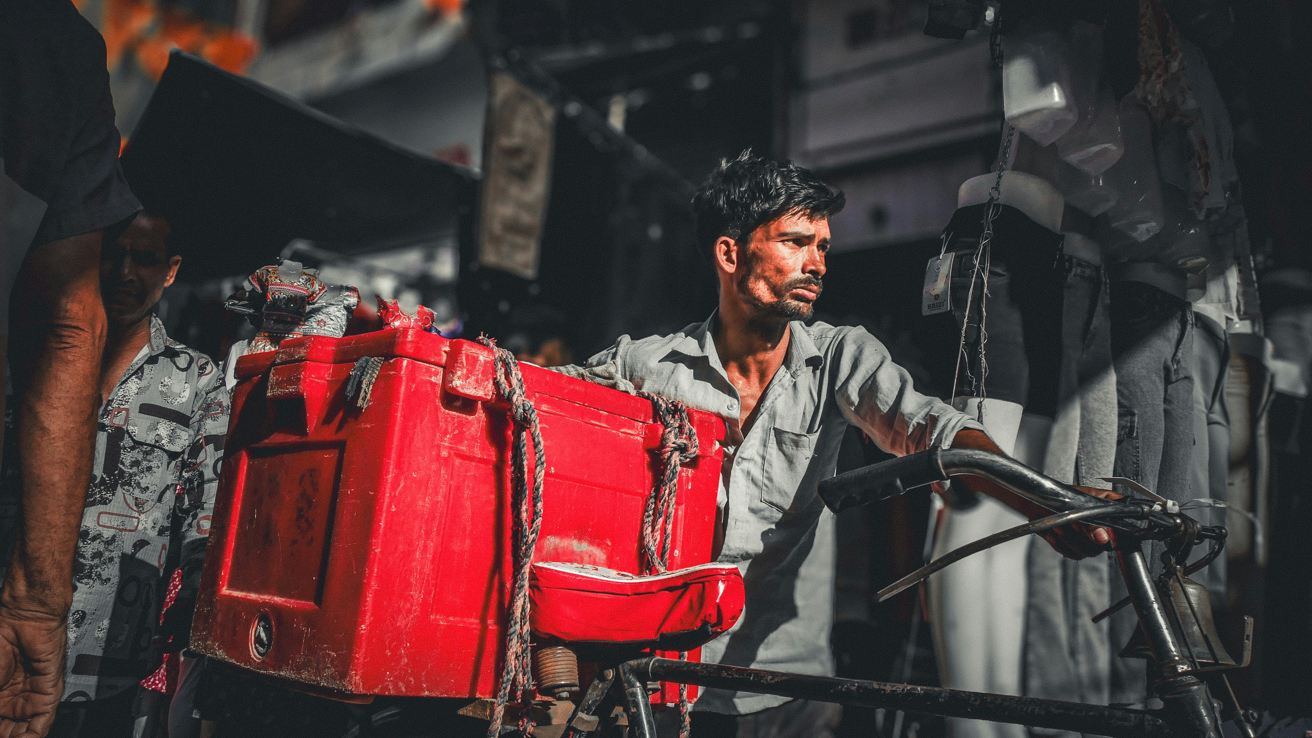 A man standing next to a red piece of luggage