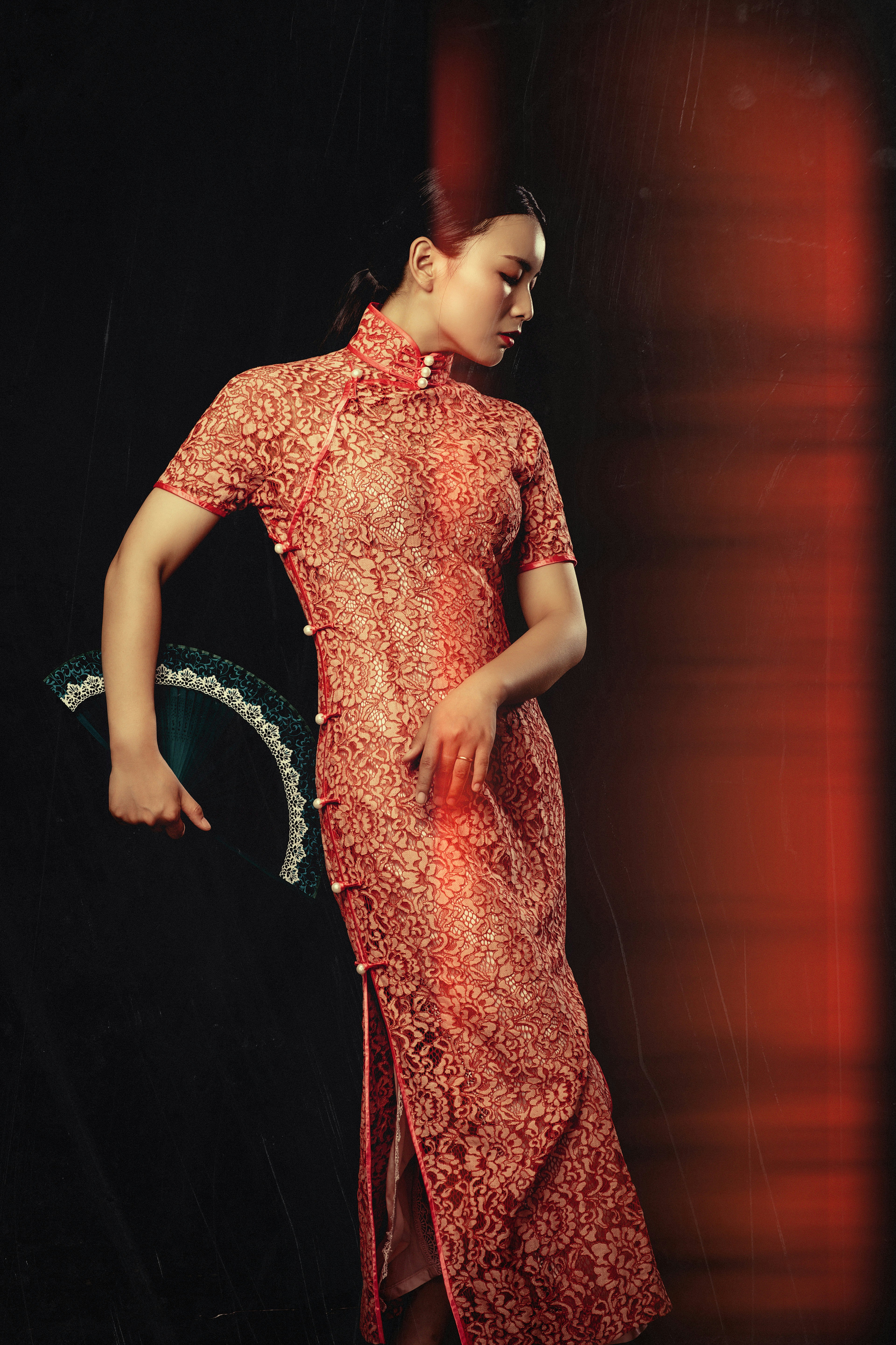 A woman in a red dress standing in front of a black background photo ...