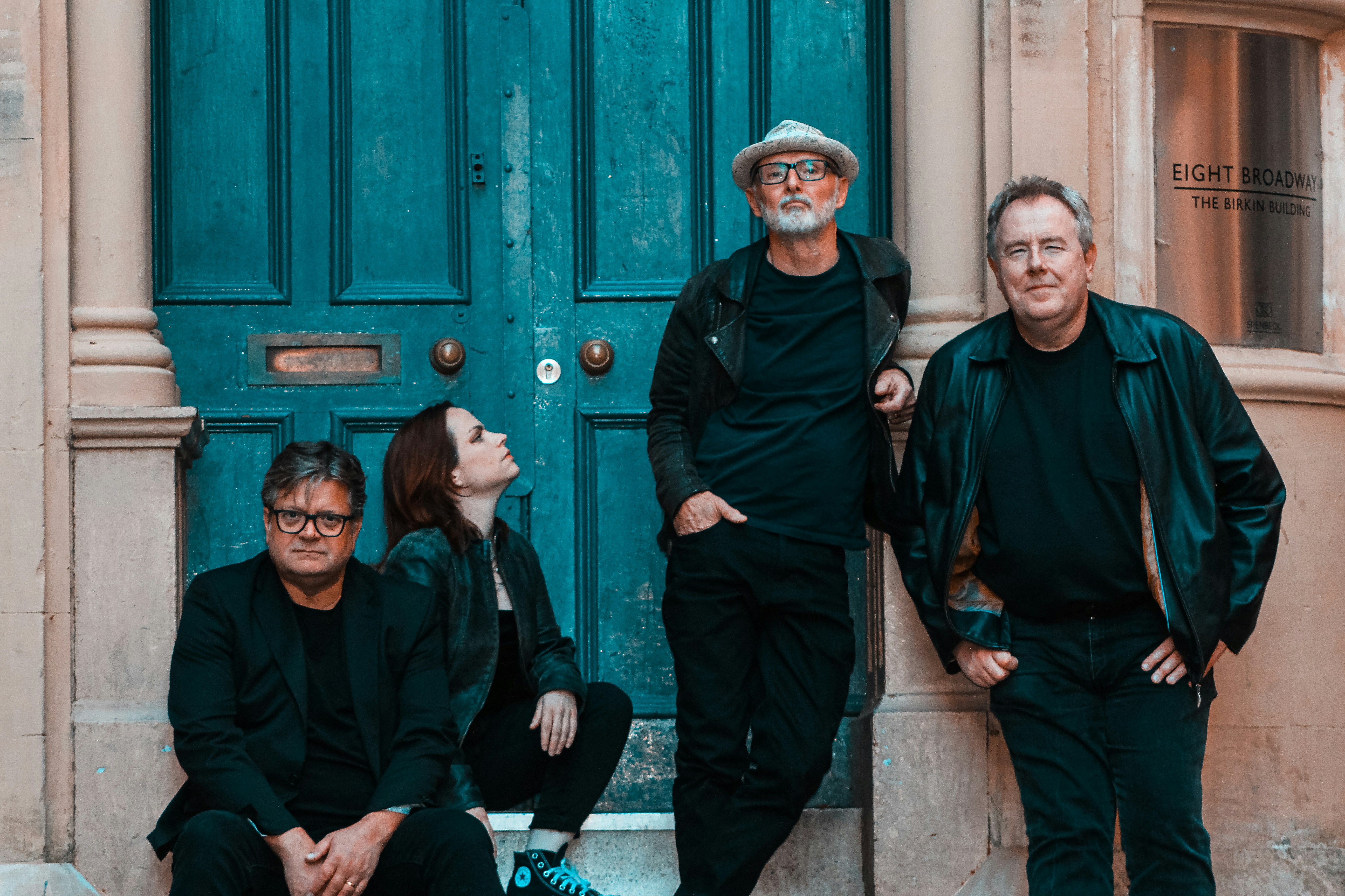 A group of people standing next to a blue door