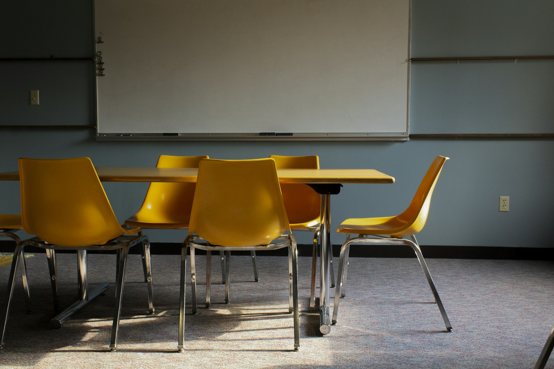 A classroom with a whiteboard and yellow chairs
