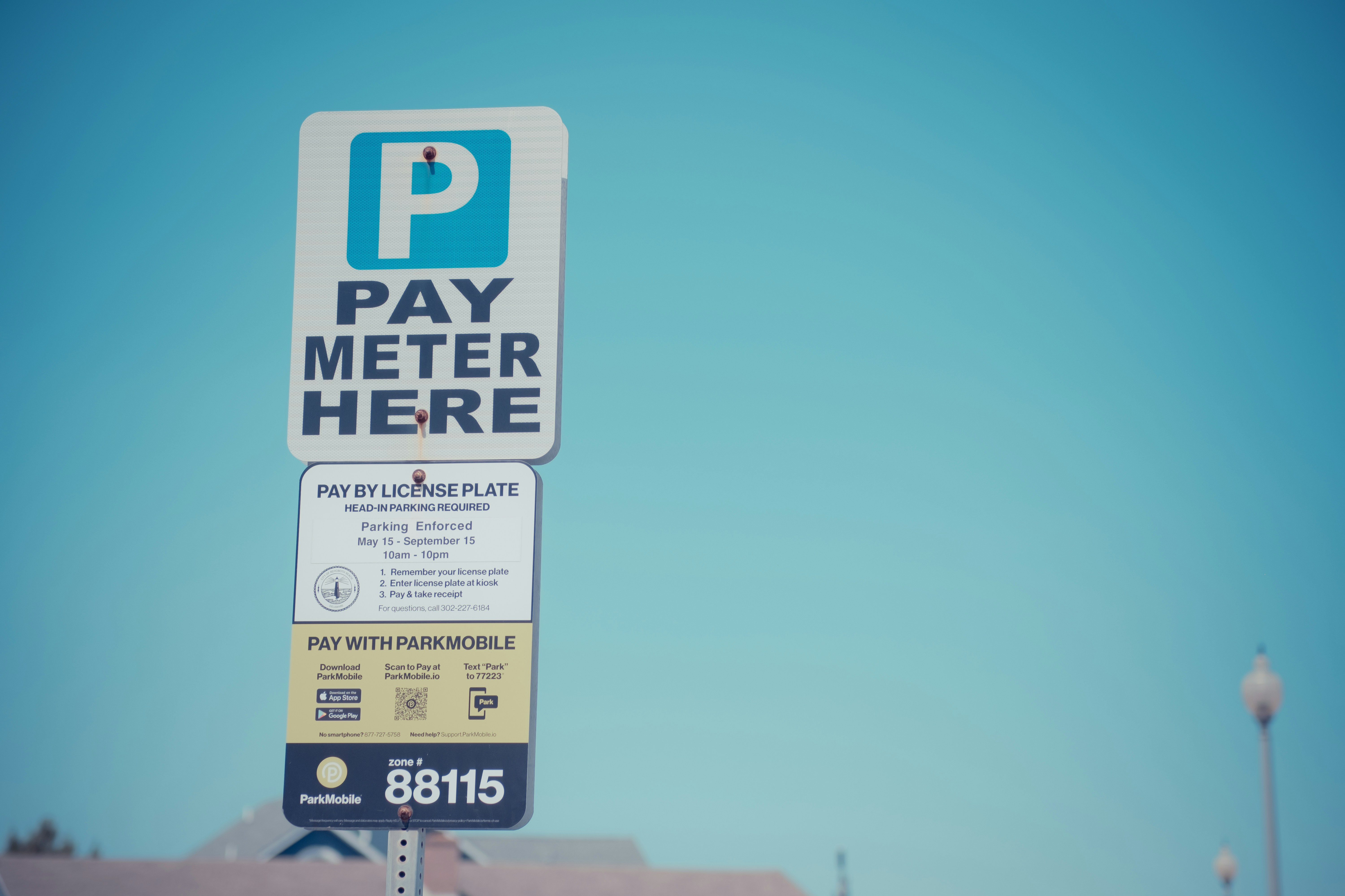 A pay meter here sign in front of a building