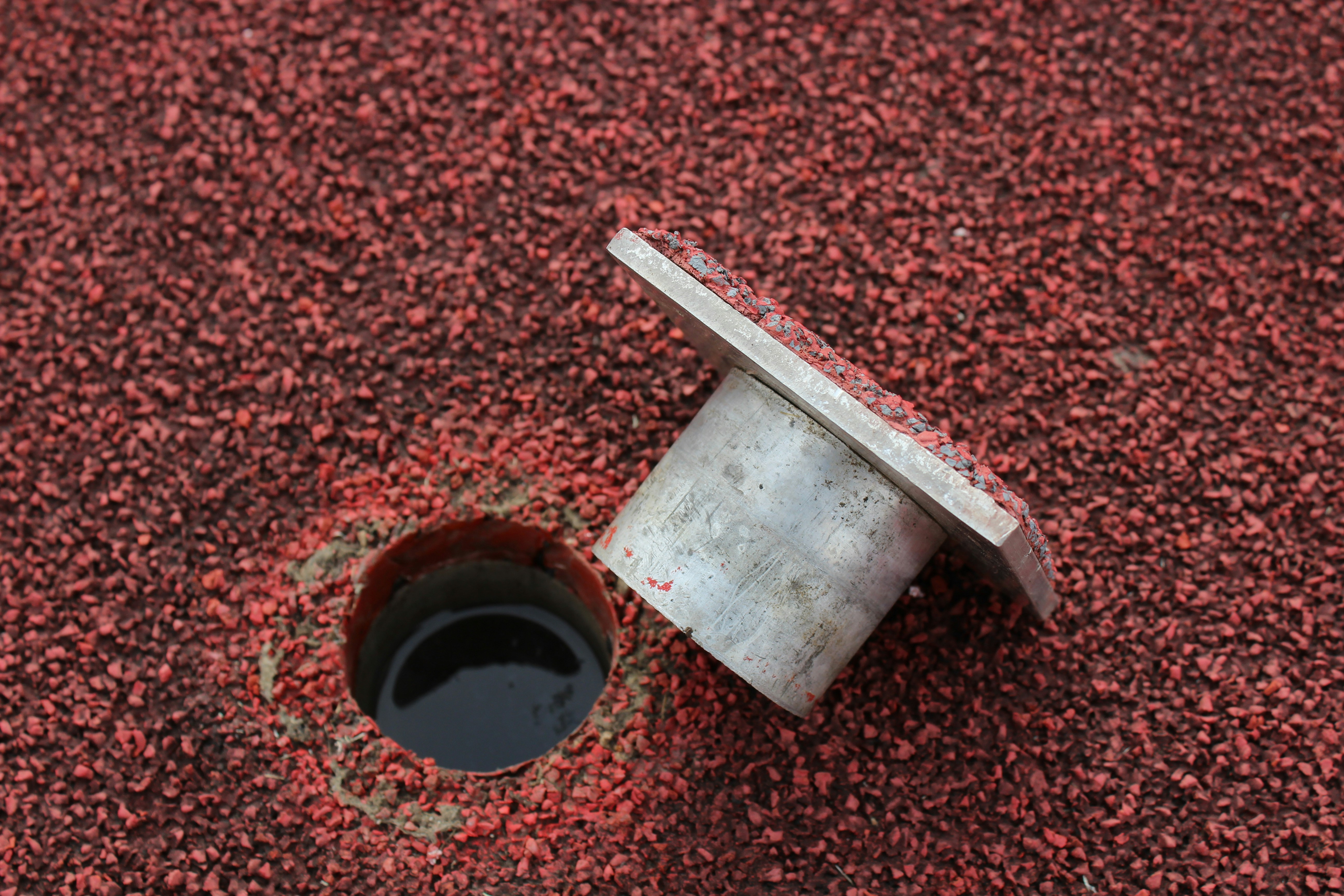 A hole in the ground with a pipe sticking out of it