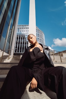 A woman in a black dress sitting on steps