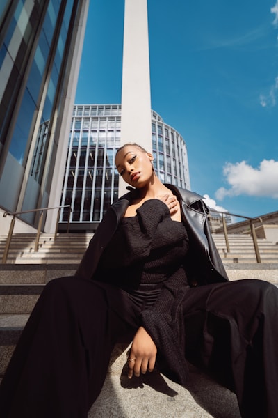 A woman in a black dress sitting on steps