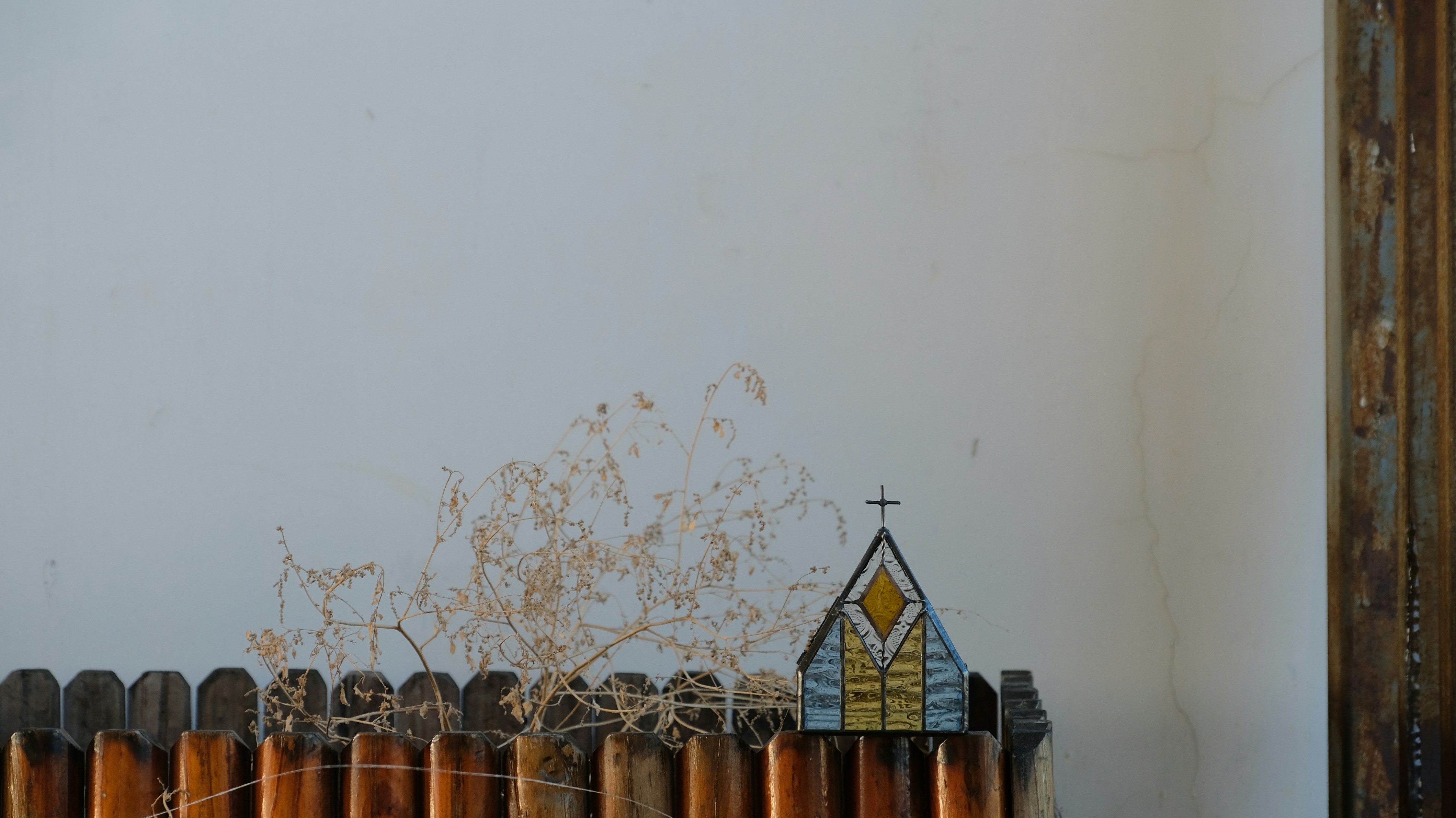 A wooden fence with a small church on top of it