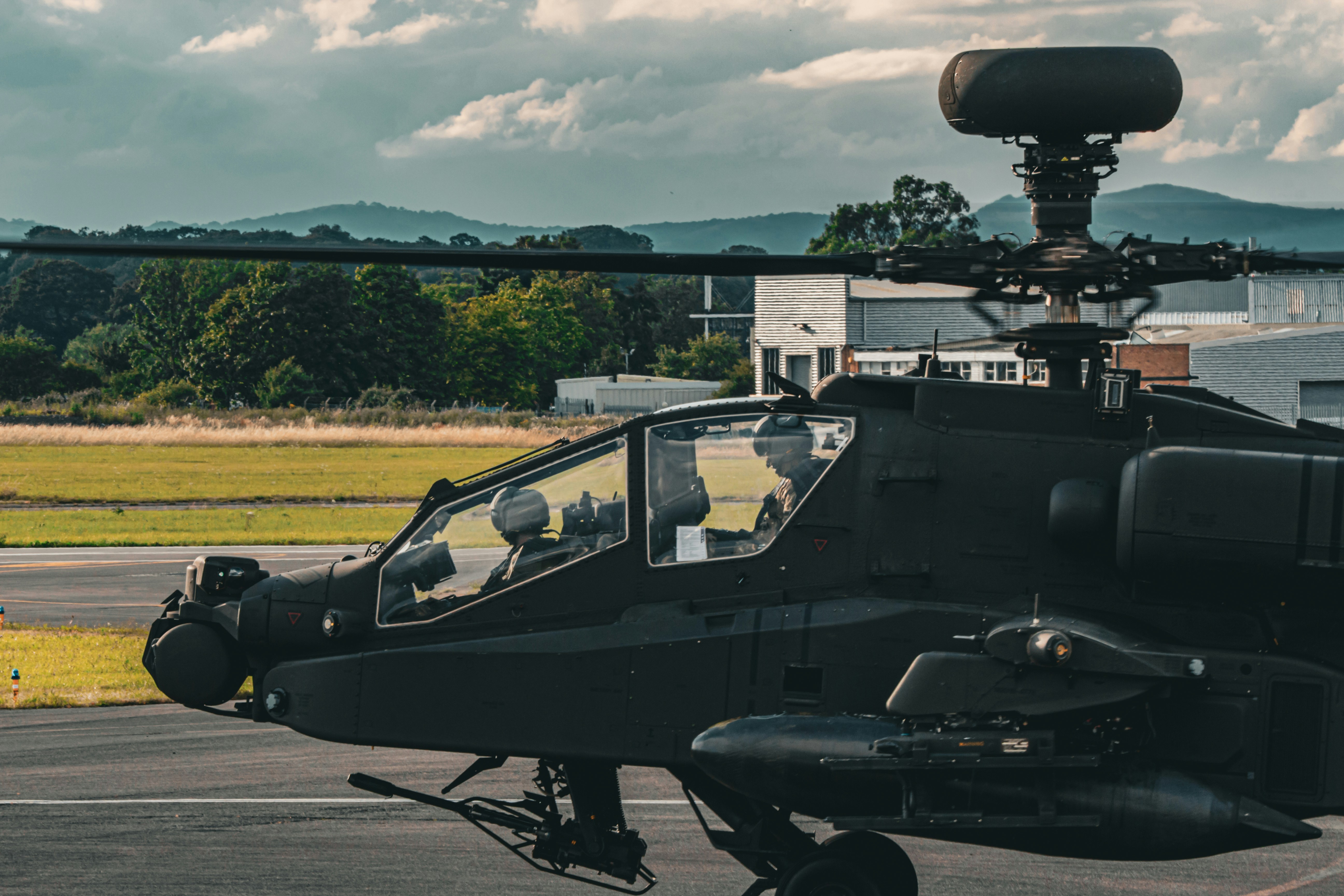 A black helicopter sitting on top of an airport tarmac