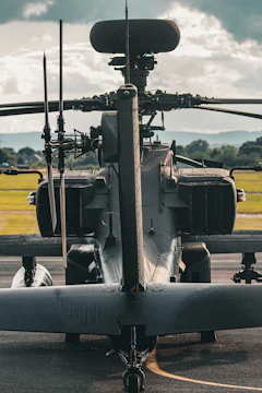 A military helicopter parked on the tarmac at an airport