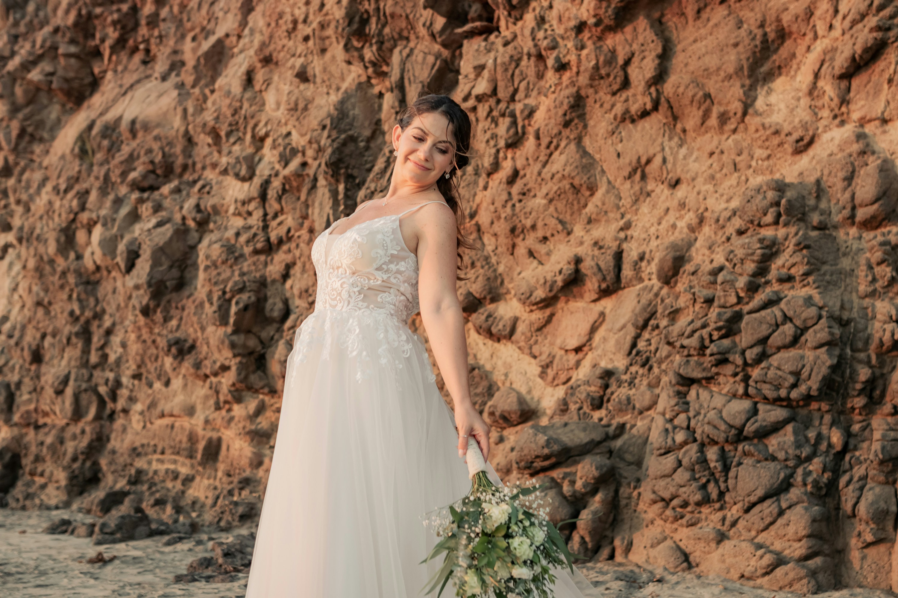 A woman in a wedding dress holding a bouquet of flowers