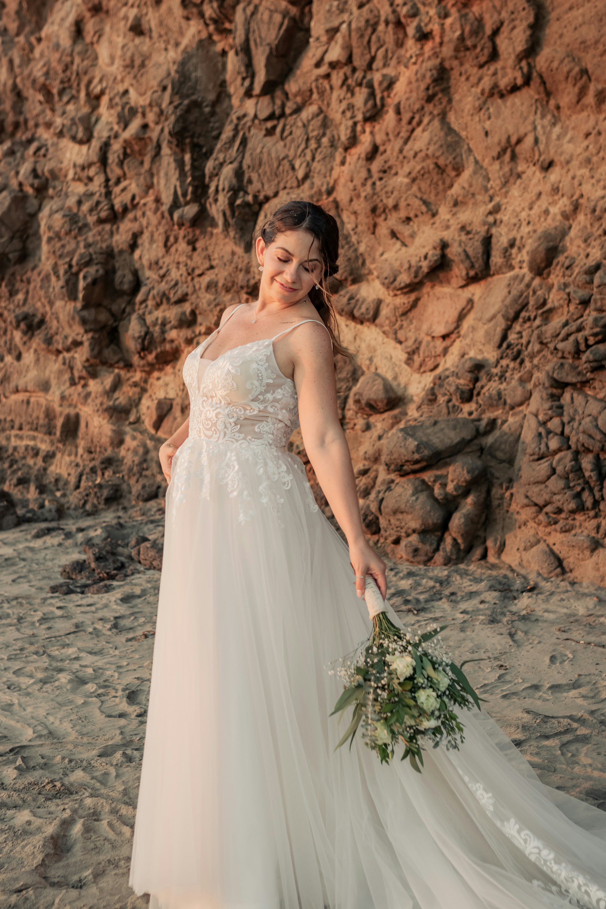 A woman in a wedding dress standing on a beach