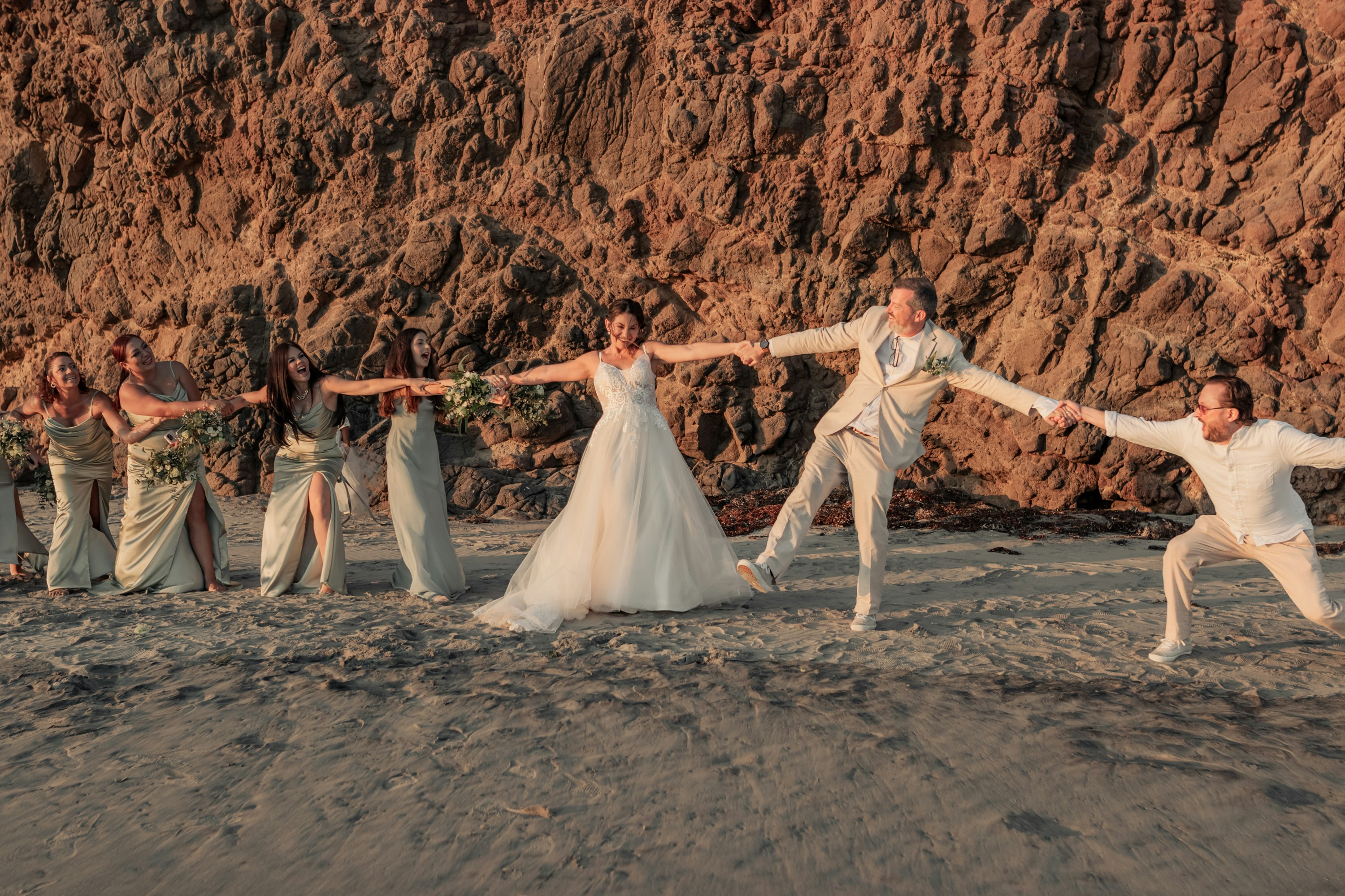 A group of people standing on top of a sandy beach