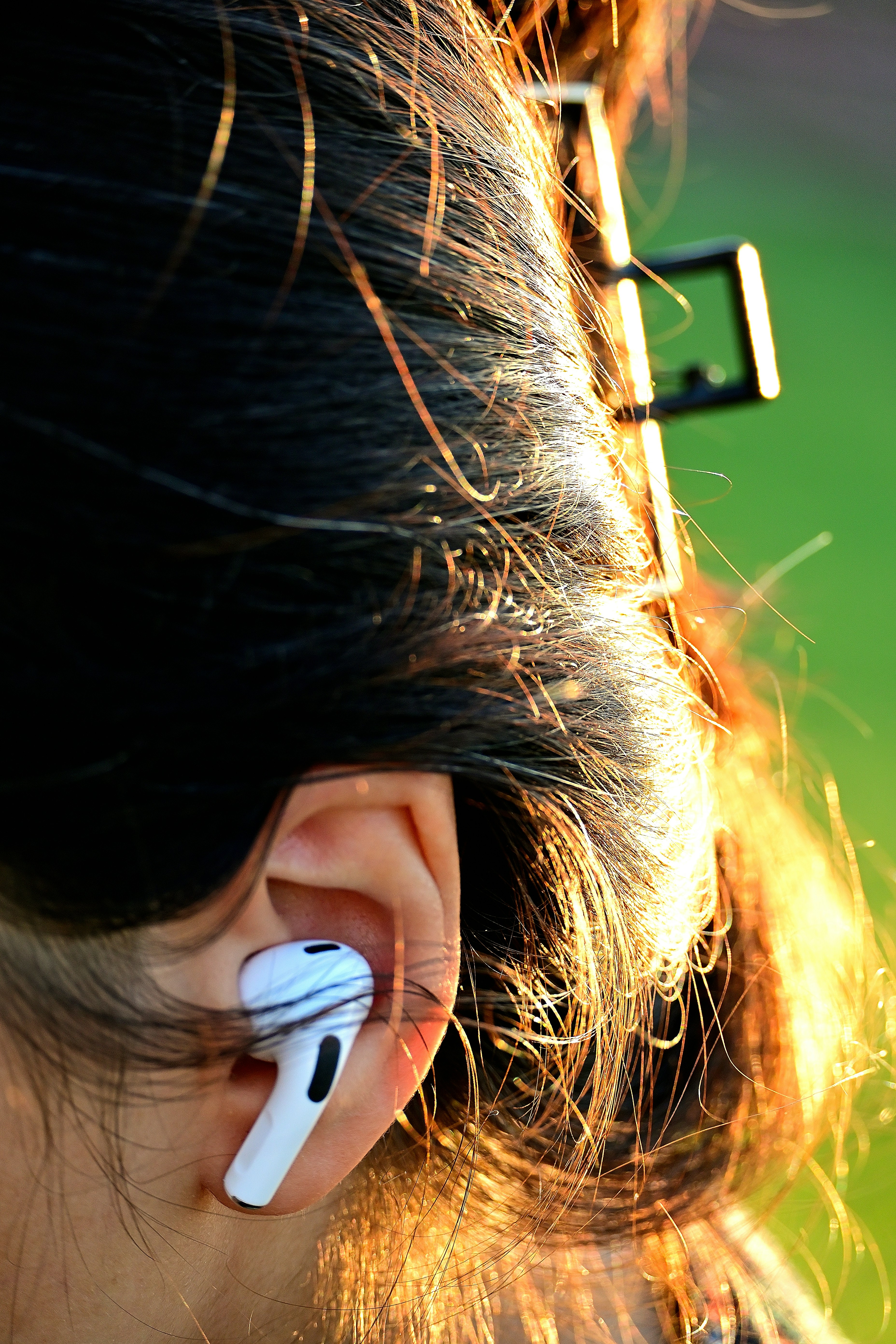 A woman with a pair of ear buds attached to her ear