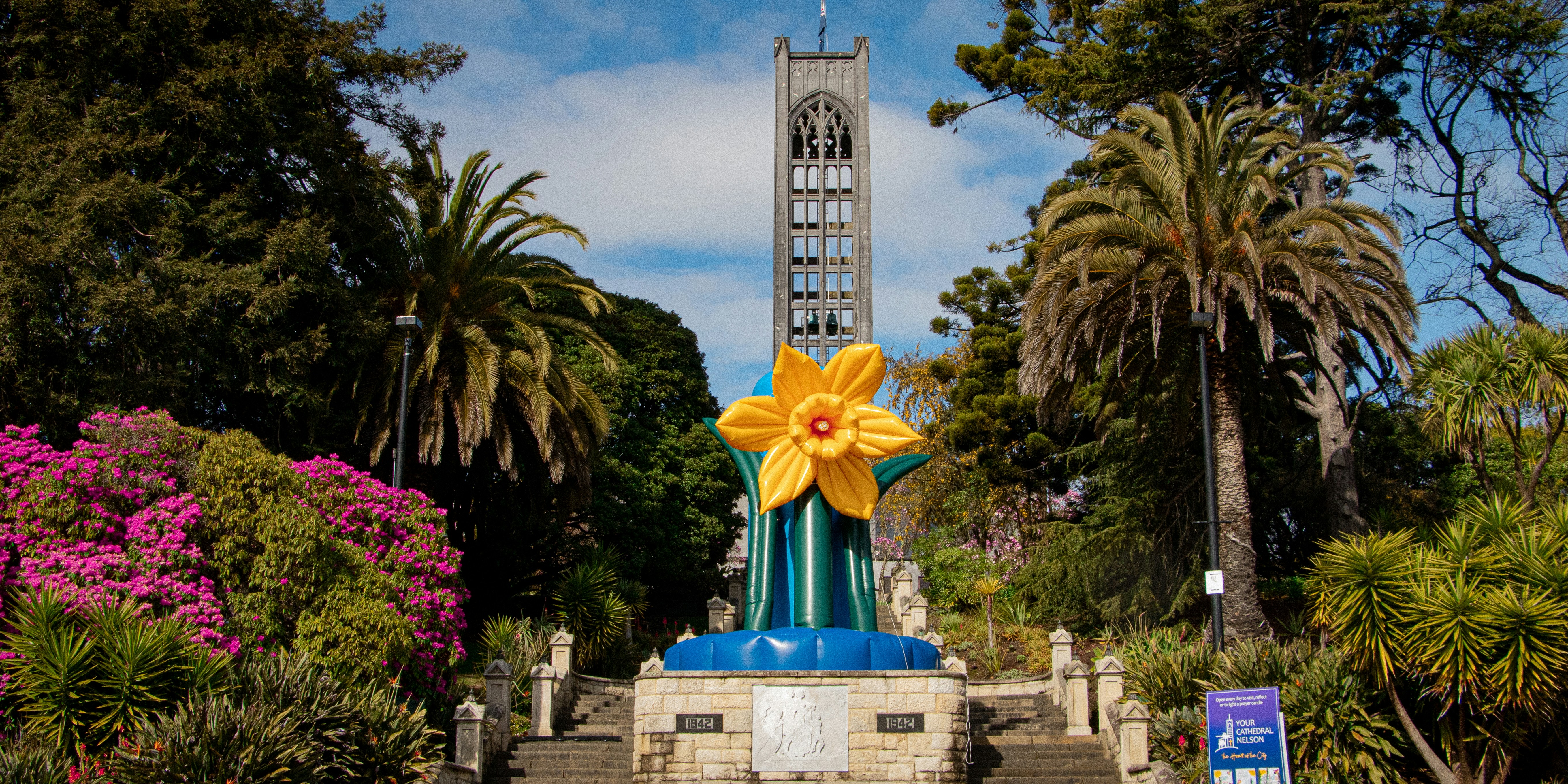 A tall clock tower towering over a park filled with trees