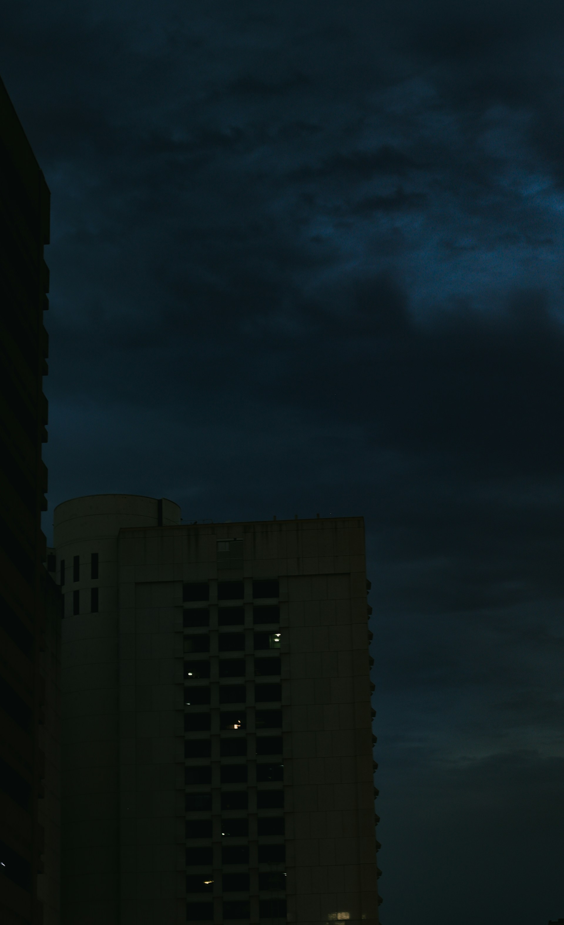 A clock tower in the middle of a city at night