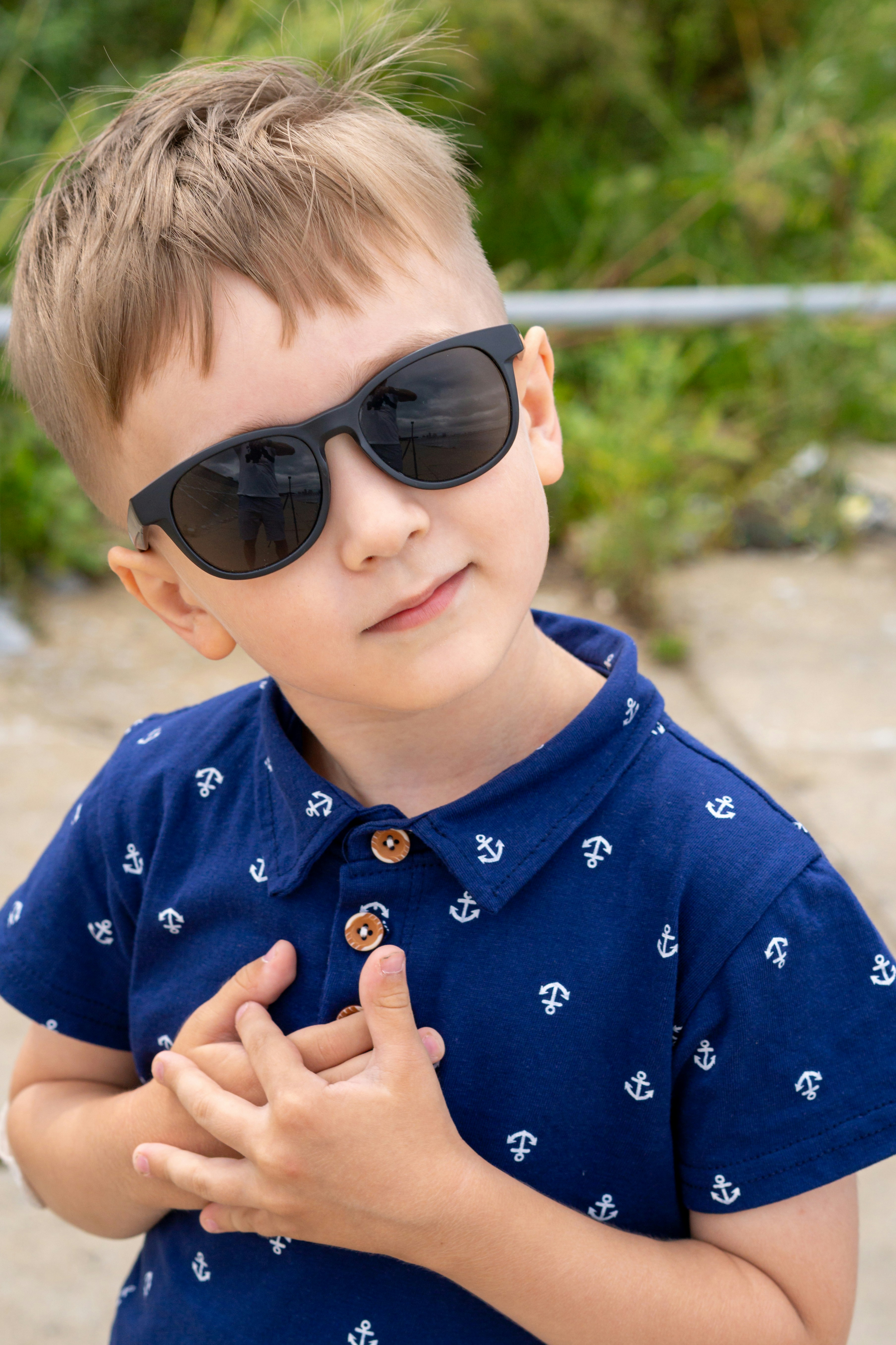 A young boy wearing sunglasses and a blue shirt