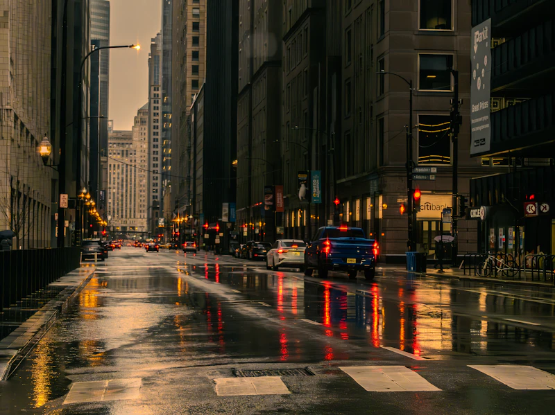 A wet Chicago city street with car light reflections on a rainy day