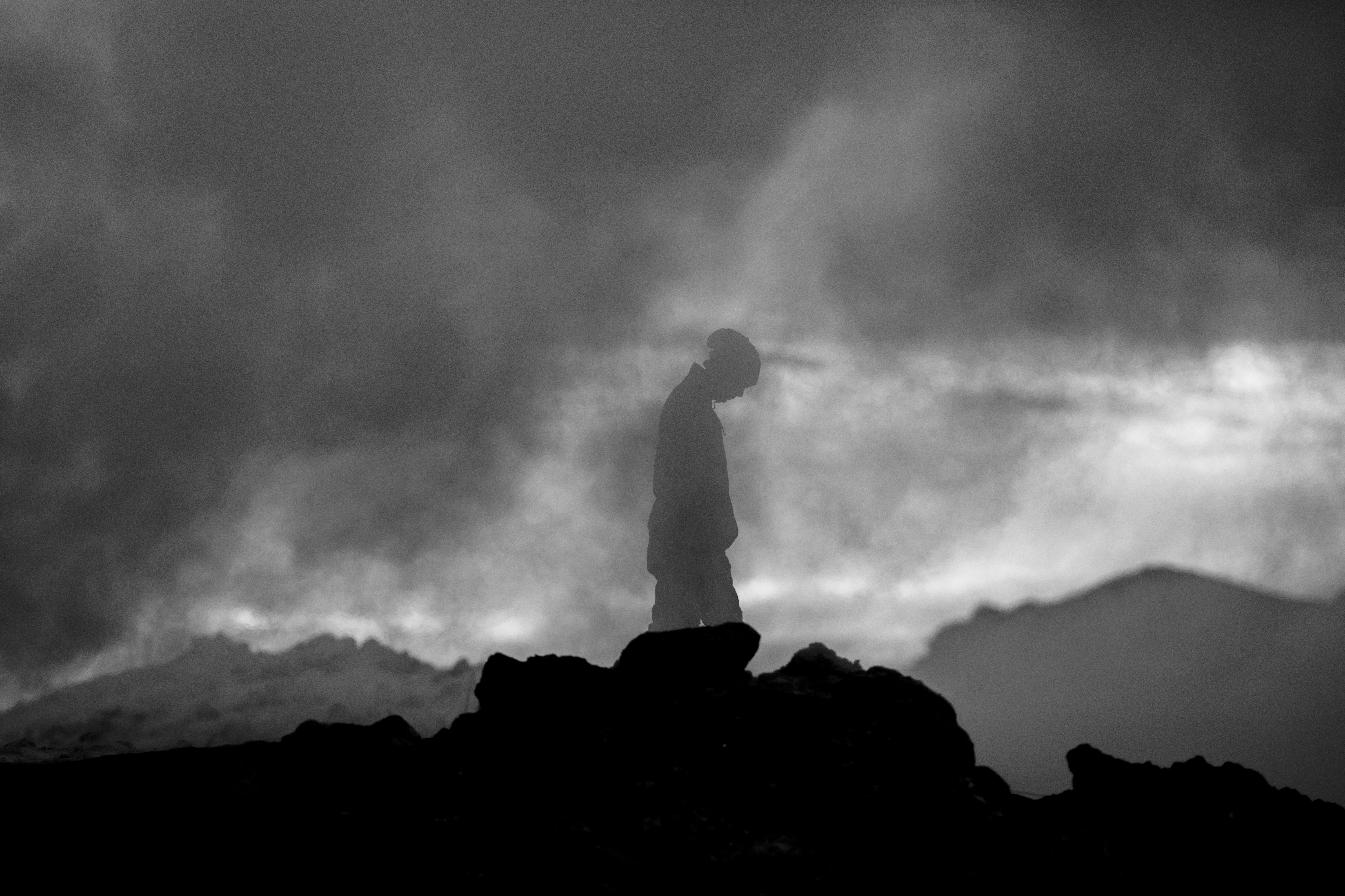A silhouette of a man standing defiantly against a stormy sky, conveying a sense of fearlessness and rebellion.