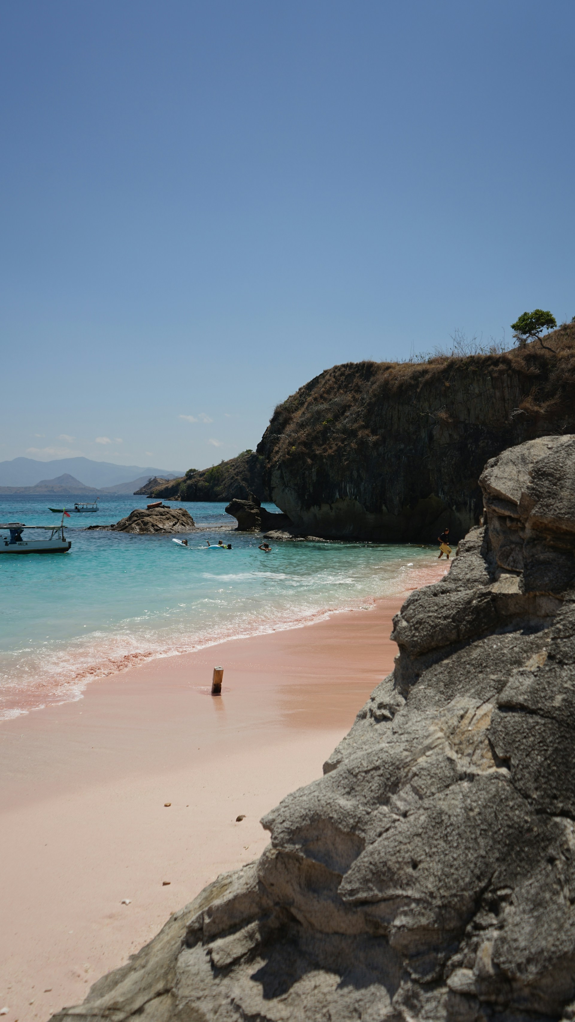 A sandy beach with a boat in the water