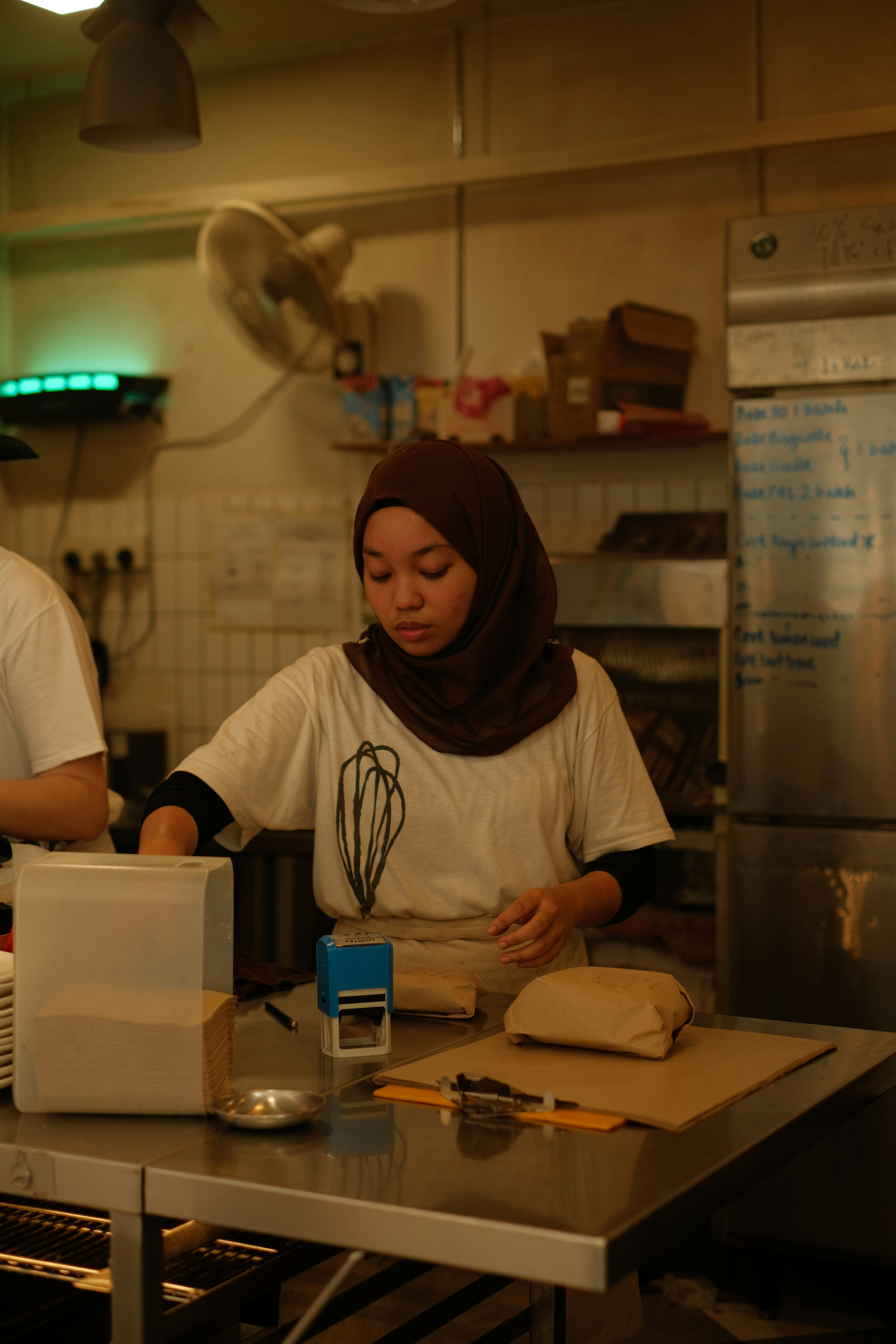 A couple of people in a kitchen preparing food