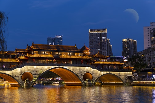A bridge over a body of water with buildings in the background