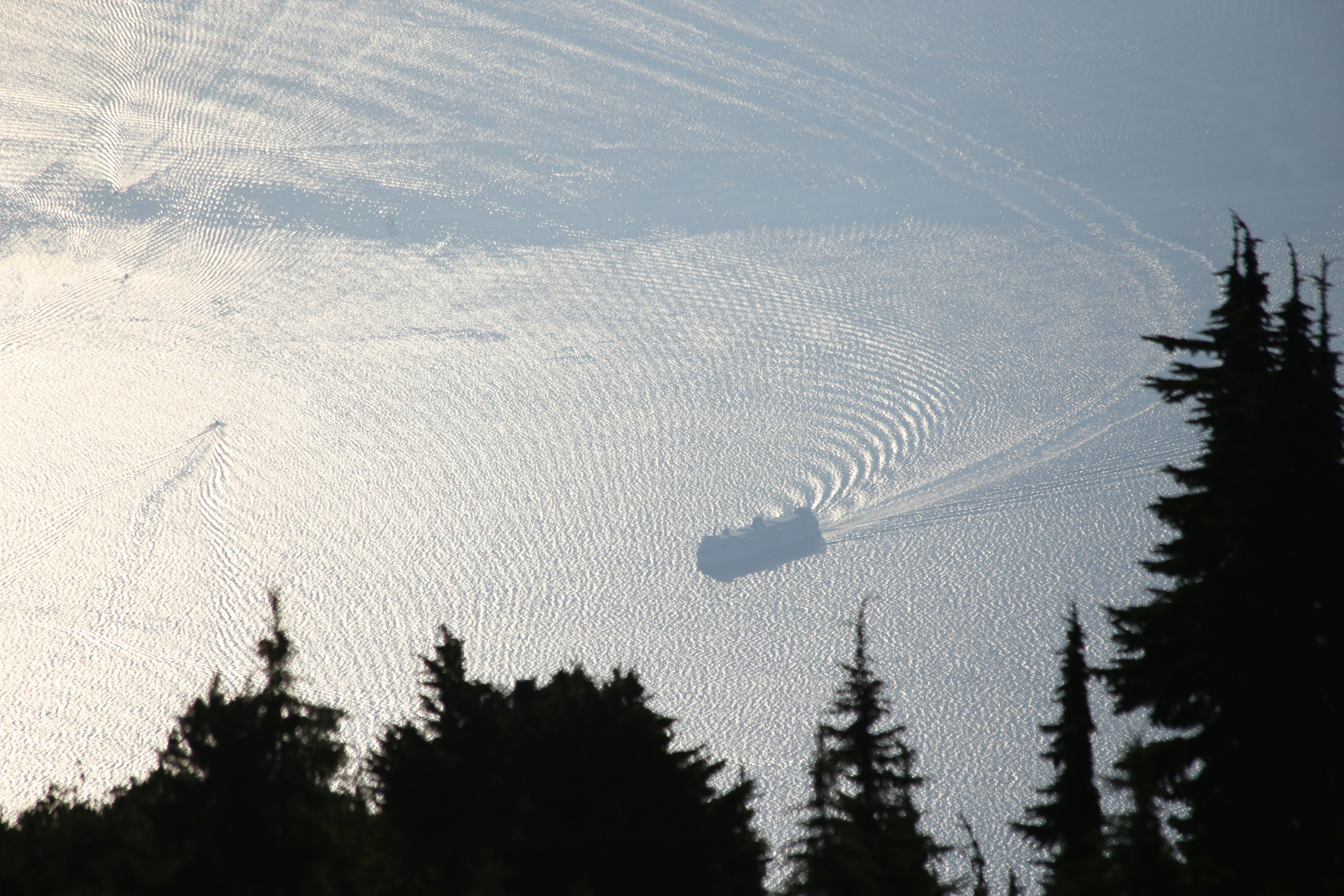 A snowboarder is going down a snowy hill