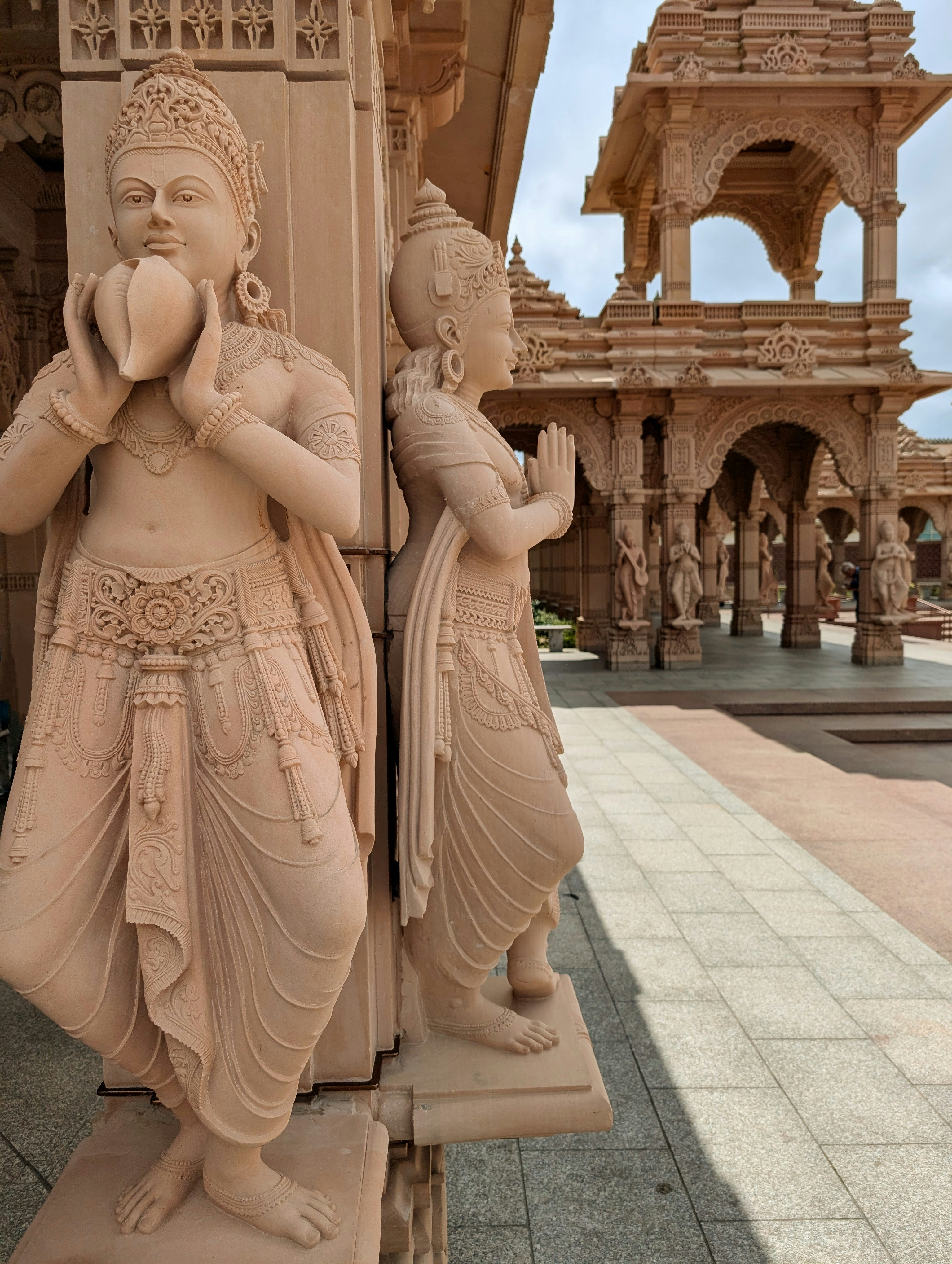 A statue of a woman holding a bird next to a building