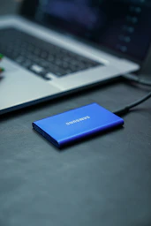 A samsung power bank sitting on a desk next to a laptop