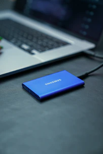 A samsung power bank sitting on a desk next to a laptop
